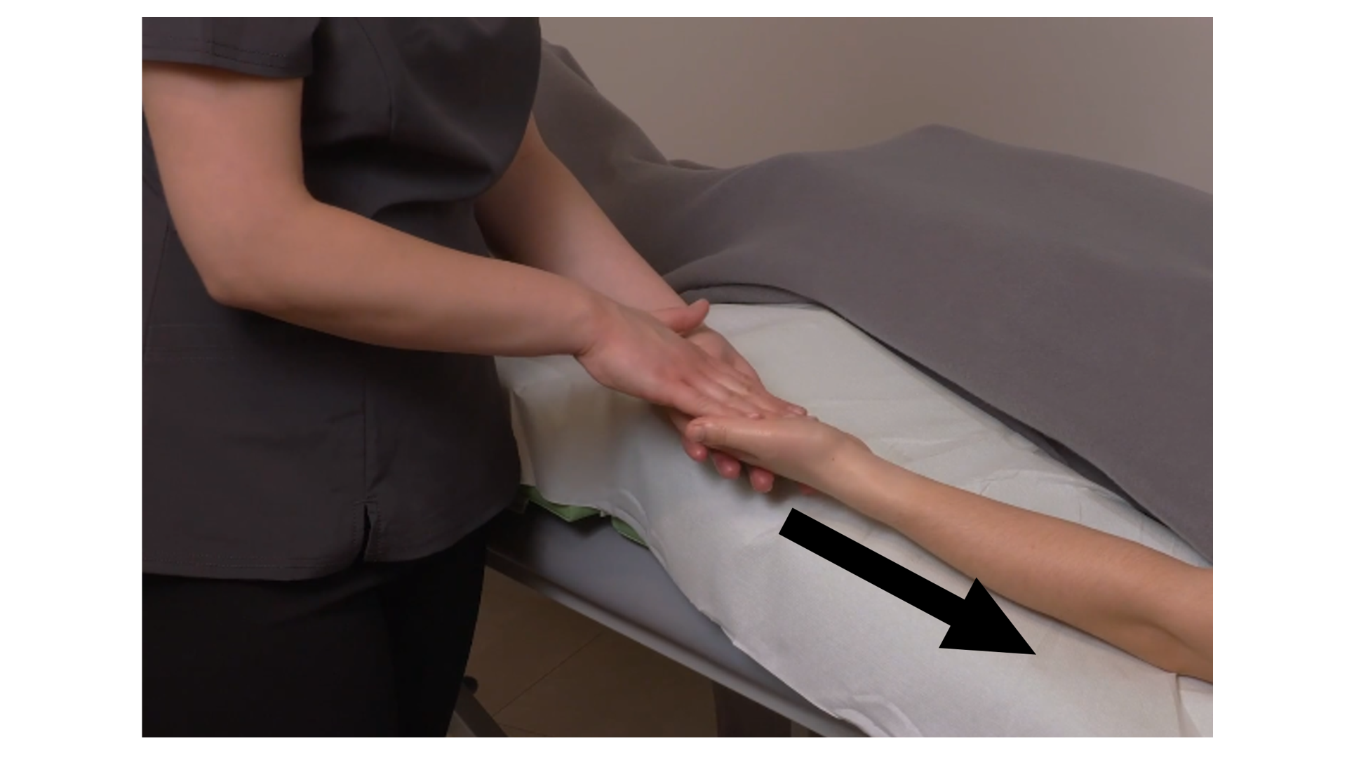 Zdjęcie pod tytułem głaskanie powierzchowne i głębokie mięśni przedramienia. Zdjęcie przedstawia masażystkę wykonującą podłużne ruchy wewnętrzną stroną ręki wzdłuż ramienia pacjentki, w kierunku od powierzchni dłoniowej ręki do łokcia.