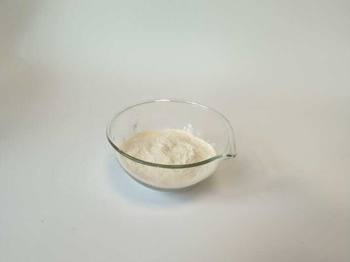 Zdjęcie przedstawia szklaną miskę z białym proszkiem - skrobią.