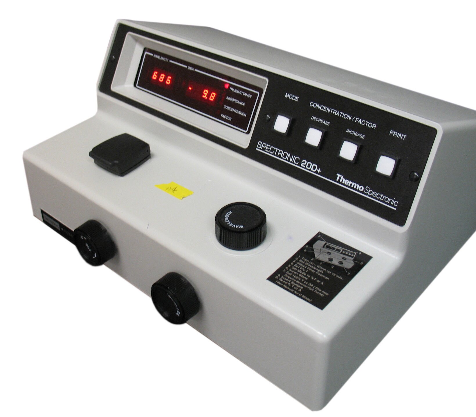 Na zdjęciu widać spektrofotometr w widoku od przodu i boku. Za górze znajduje się wyświetlacz i przyciski do obsługi urządzenia. Znajdują się na nim również pokrętła do obsługi urządzenia, które są umieszczone z przodu i na górze.
