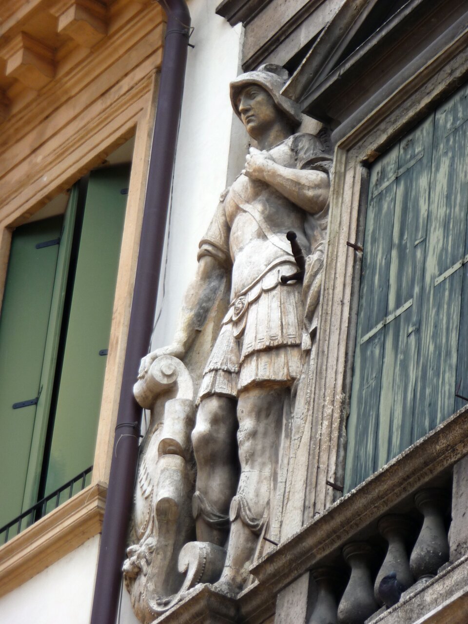 Ilustracja o kształcie poziomego prostokąta przedstawia  detal fasady z płaskorzeźbą wojownika, która znajduje się na budowli Palazzo Valmarana. Postać ma na sobie antykizującą zbroję. Prawa ręka wojownika spoczywa na tarczy, na której znajduje się inskrypcja.