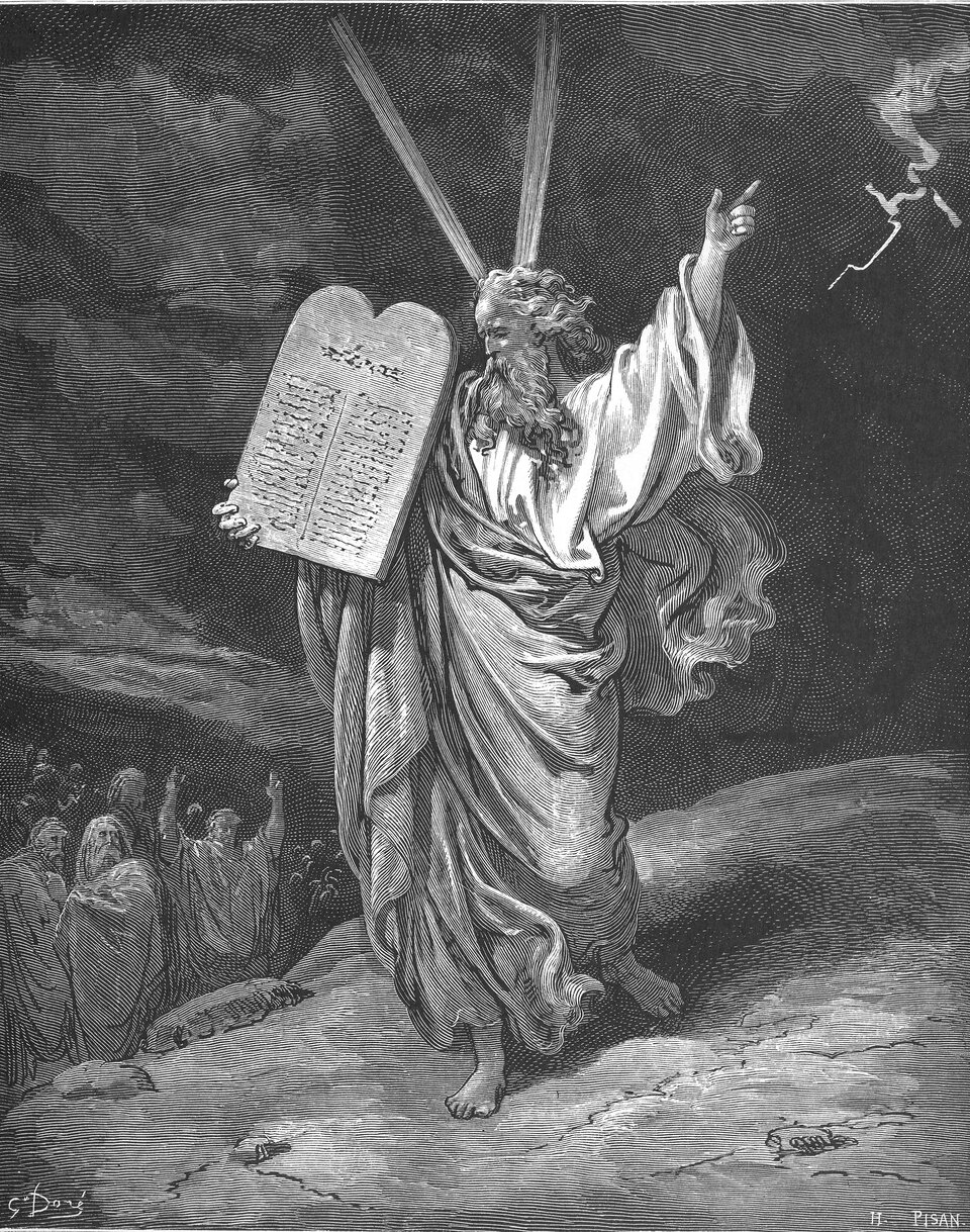 Ilustracja przedstawia starego mężczyznę, stojącego na niewielkim wzgórzu, ubranego w długie szaty i trzymającego w jednym ręku dwie prostokątne, kamienne tablice, zakończone półkolem. Tablice są gęsto zapisane. Mężczyzna wskazuje palcem na niebo. Nad nim widać błyskawicę. W lewym dolnym rogu widać grupę ludzi przyglądających się Mojżeszowi. Jeden człowiek uniósł obie ręce do góry.