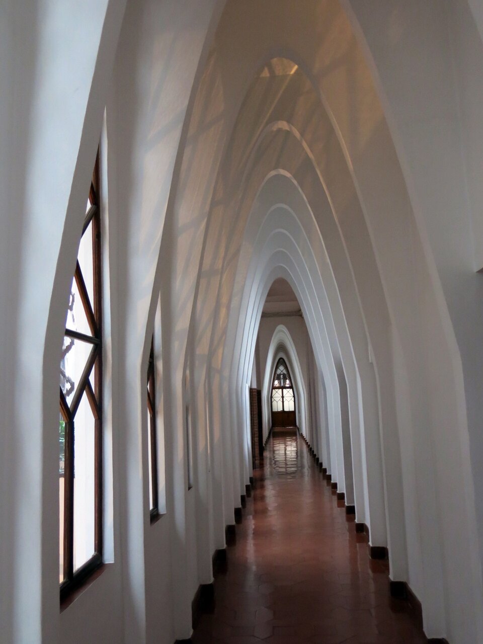 Ilustracja o kształcie pionowego prostokąta przedstawia dziedziniec Kolegium Terezjanek. Zdjęcie przedstawia fragment korytarza dekorowanego łukami o smukłym, prawie ostrym zakończeniu. Pomiędzy łukami znajdują się w oknach okna. Na końcu korytarza widoczne są przeszklone drzwi. 