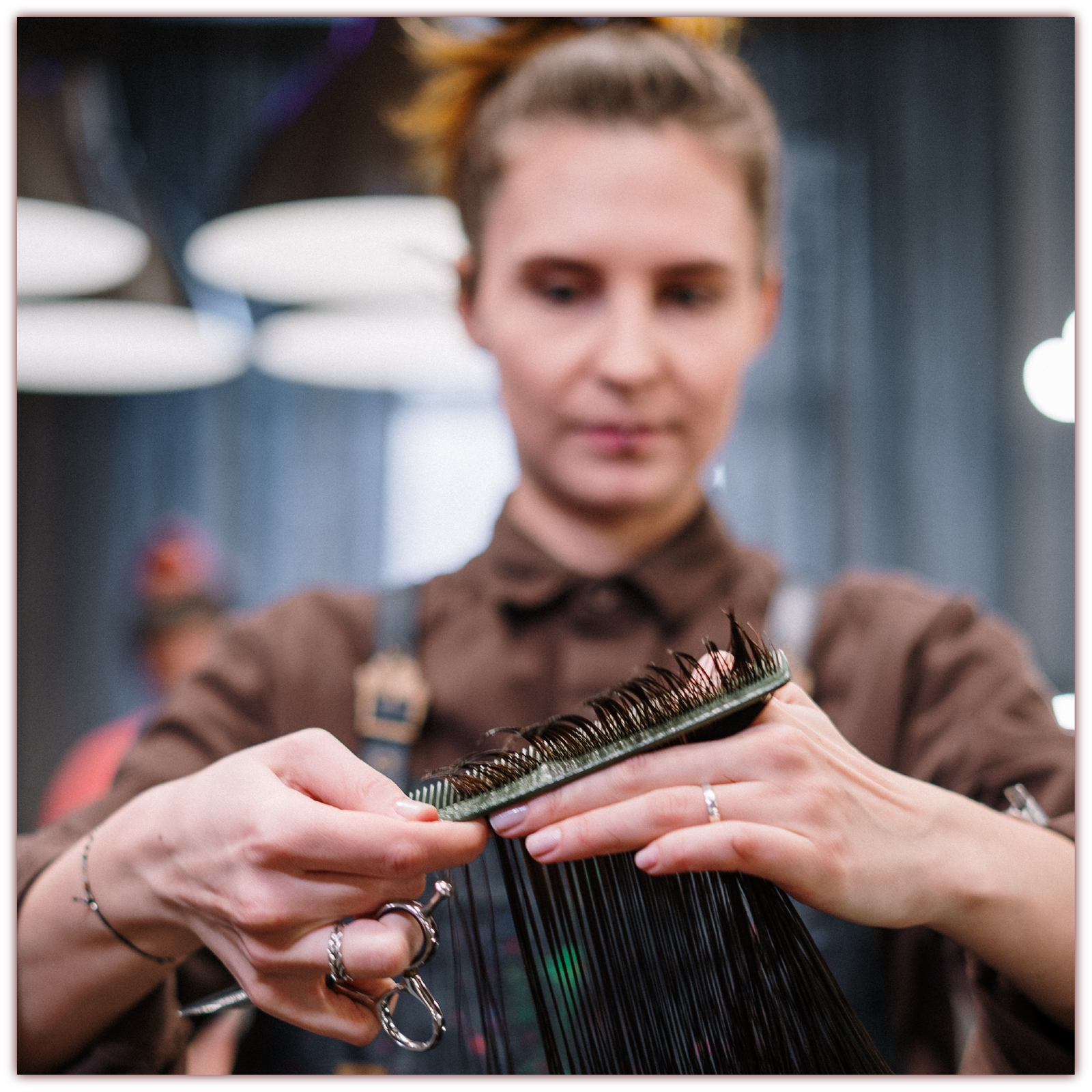 Grafika przedstawia kobietę obcinającą włosy klientce.