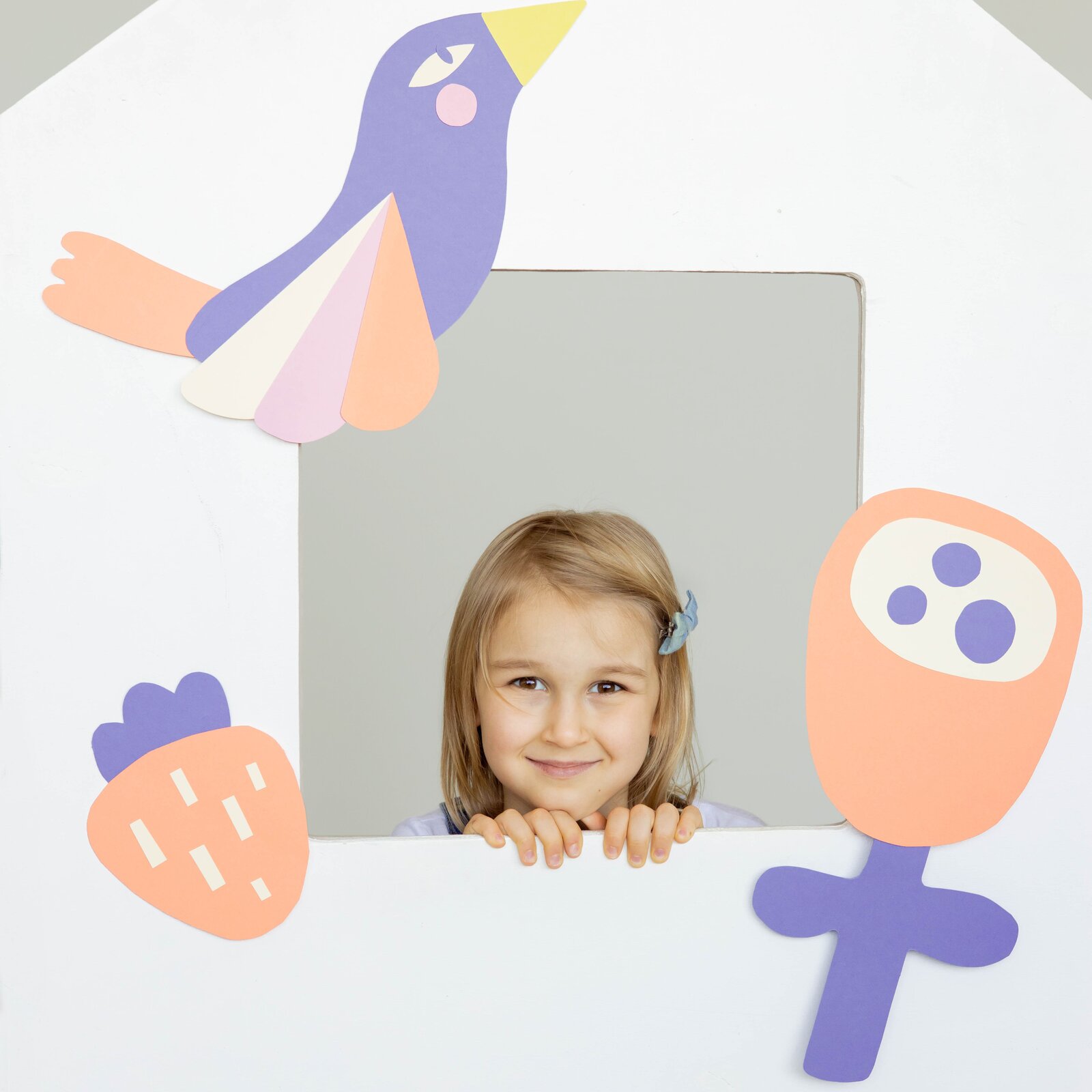 Ilustracja przedstawia główkę dziewczynki w ramce. Obok narysowane są kwiatek, truskawka i ptaszek.  