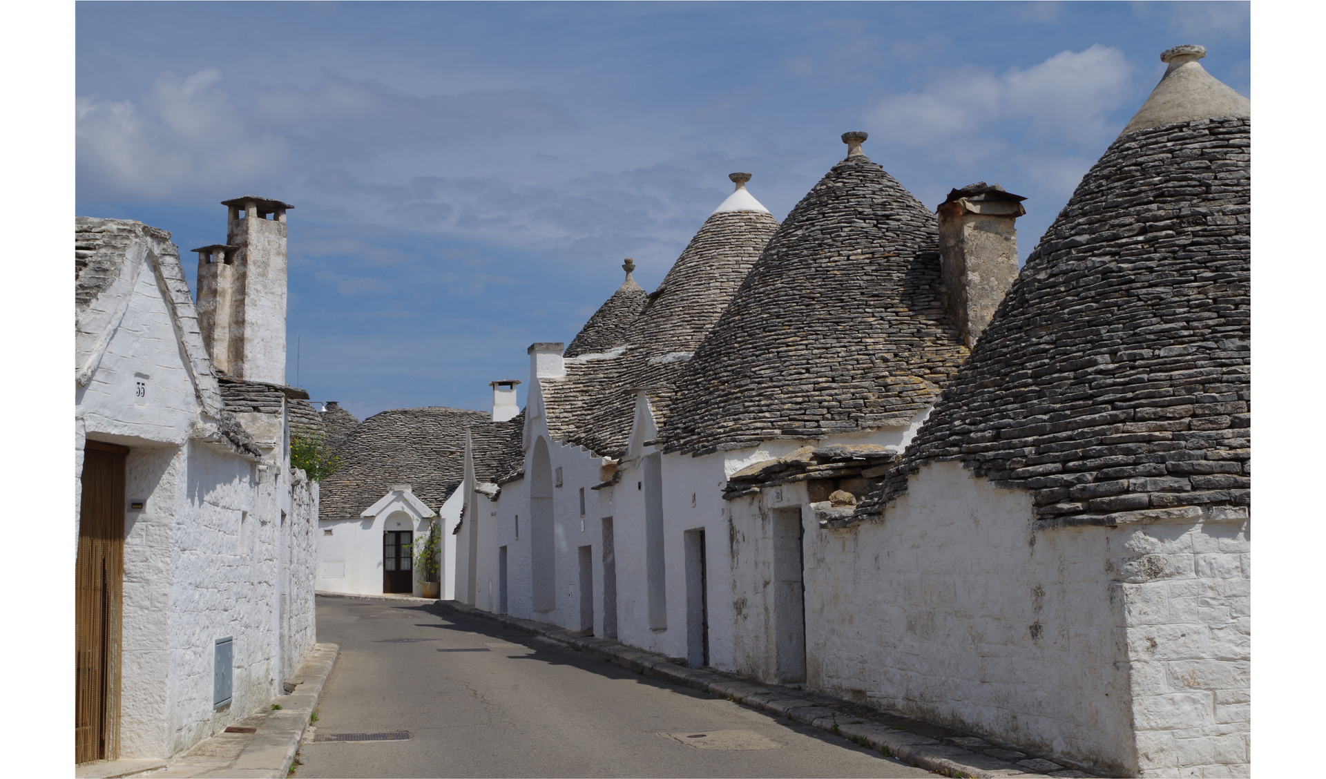 Zdjęcie przedstawia charakterystyczne domki Trulli w mieście Alberobello we Włoszech.
