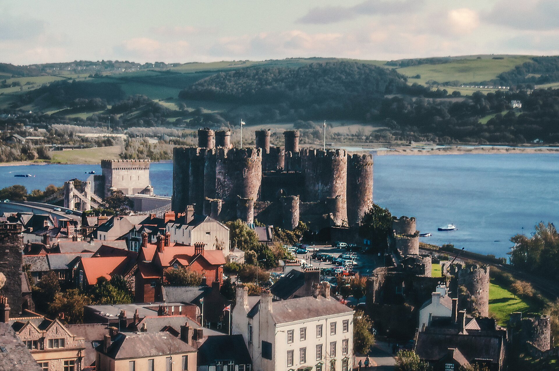 Zdjęcie przedstawia wioskę nad zatoką, nad którą góruje zamek warowny. 