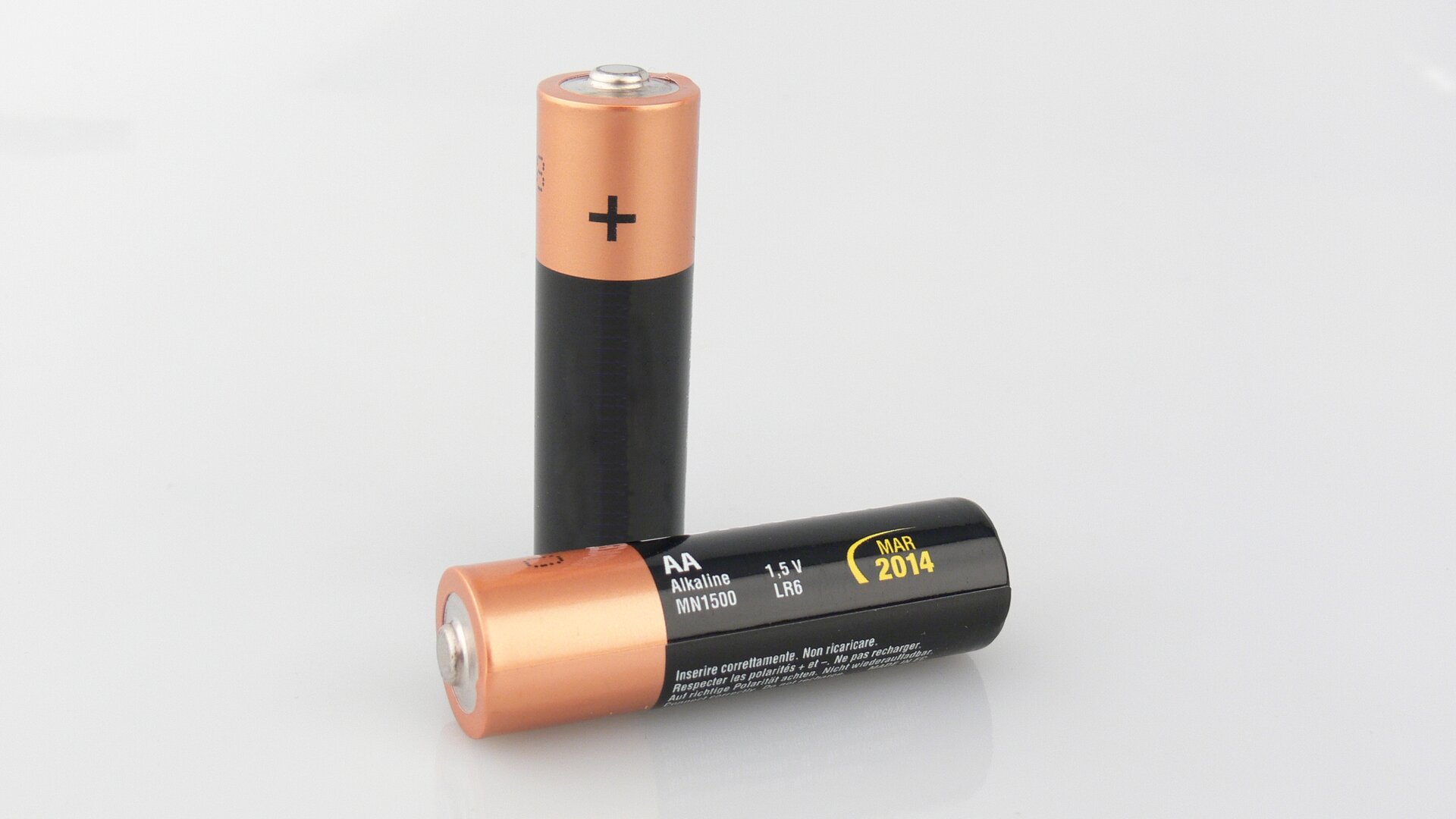 Ilustracja przedstawia baterię półtora woltową, tak zwany paluszek, typ AA. Ma kształt krótkiego walca z wystającym bolcem na jednej z podstaw.