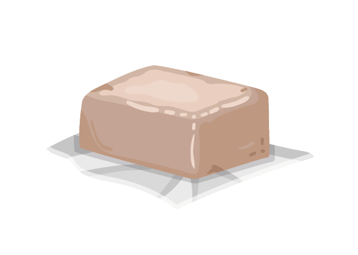 Grafika przedstawia kostkę drożdży świeżych w kolorze jasnobrązowym, leżącą na rozłożonej folii.