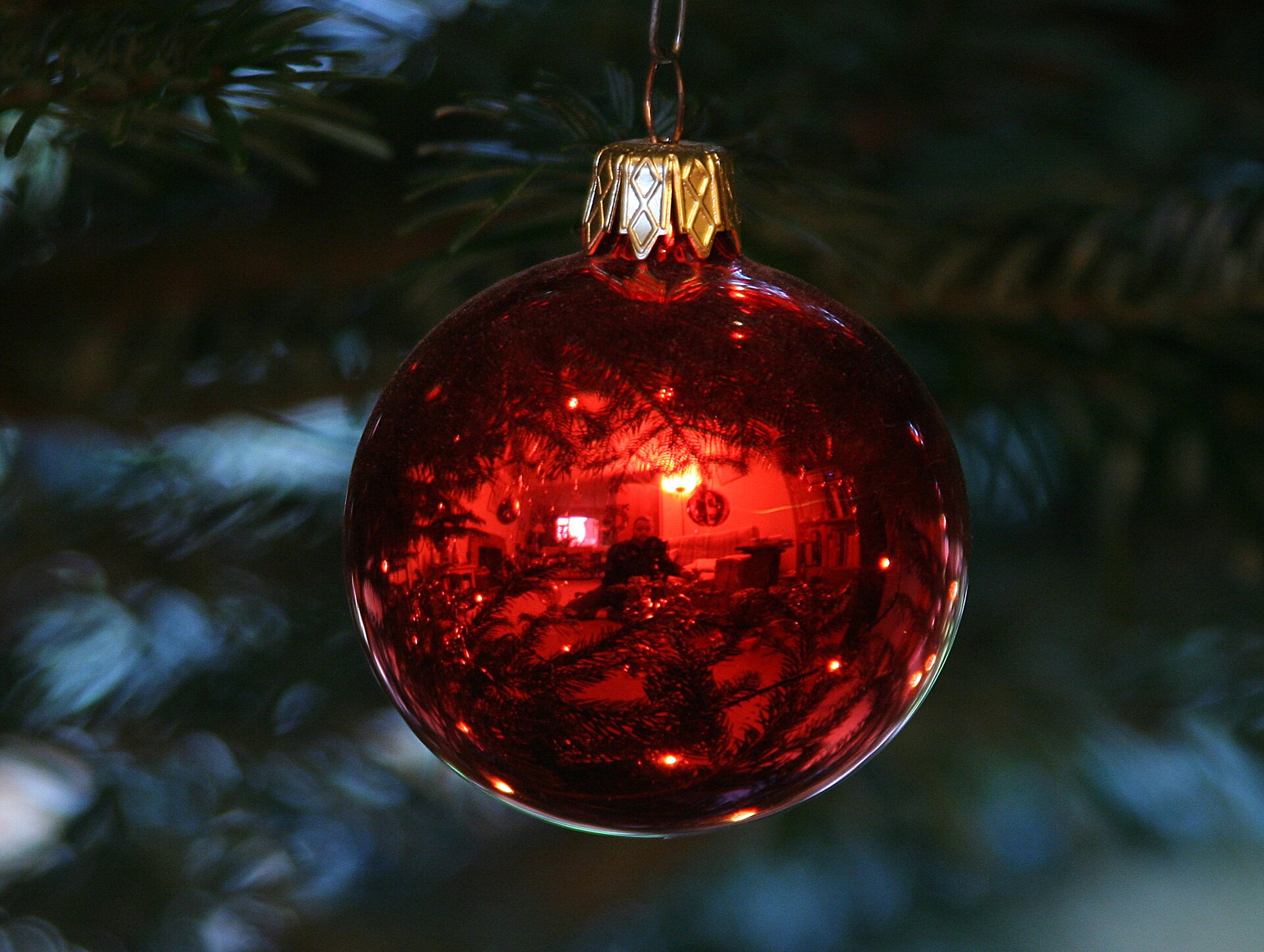 Zdjęcie przedstawiające czerwoną bombkę choinkową - przykład zwierciadła kulistego wypukłego.