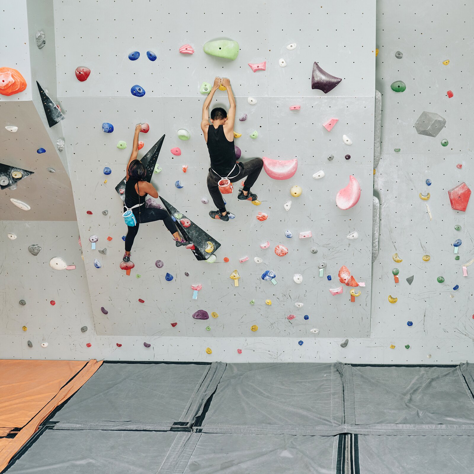Zdjęcie przedstawia dwie osoby wchodzące na ściankę pspinaczkową. 