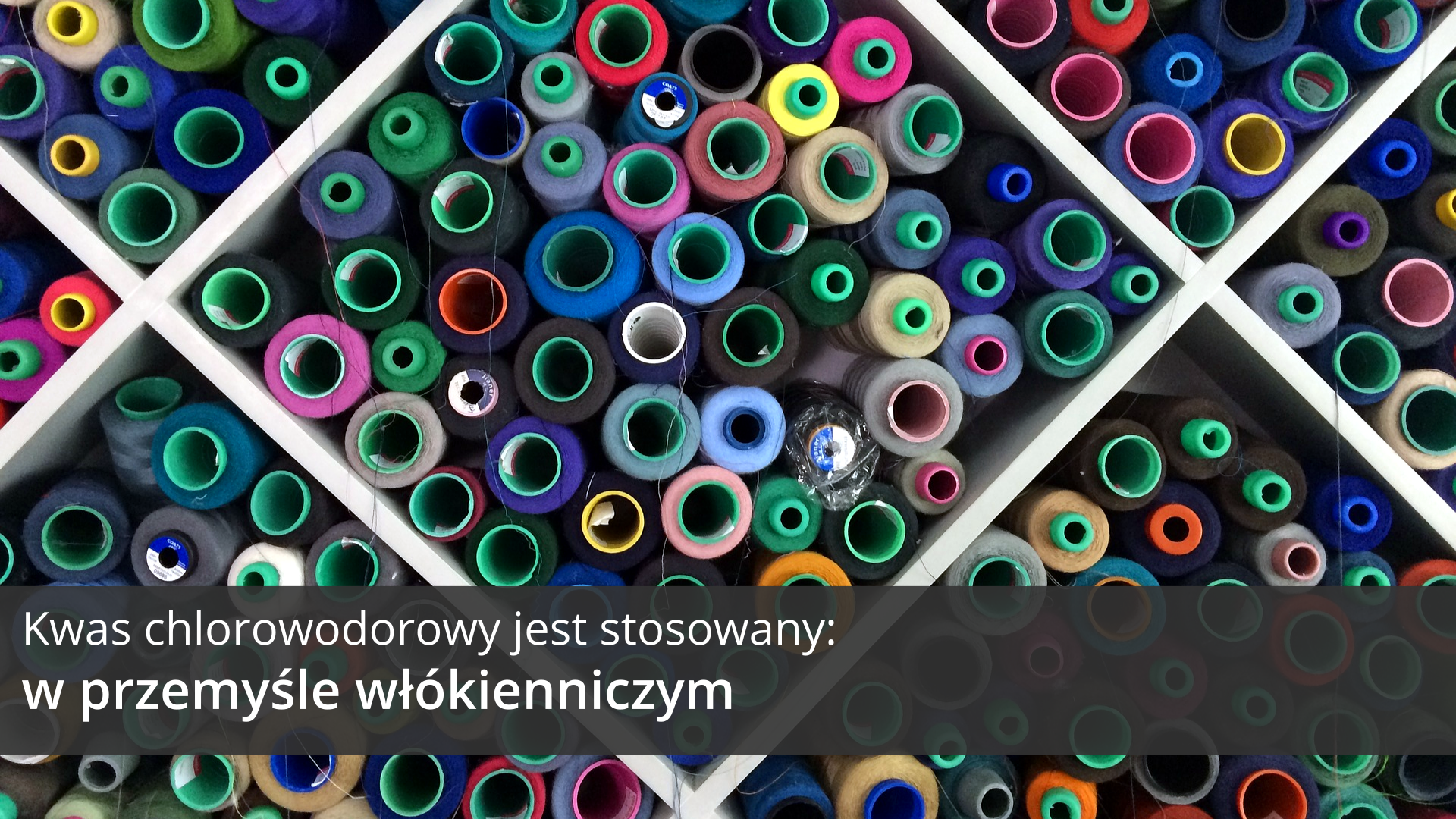 Trzecia ilustracja galerii przedstawia fragment otwartego pojemnika z dużymi przegródkami o kształtach rombów wypełnionymi dużą liczbą różnokolorowych zwitków nici oglądanych z góry. Na tle obrazka, w dolnej części ilustracji, znajduje się ciemnoszary pasek, na którym umieszczono jasny napis: Kwas chlorowodorowy jest stosowany w przemyśle włókienniczym.