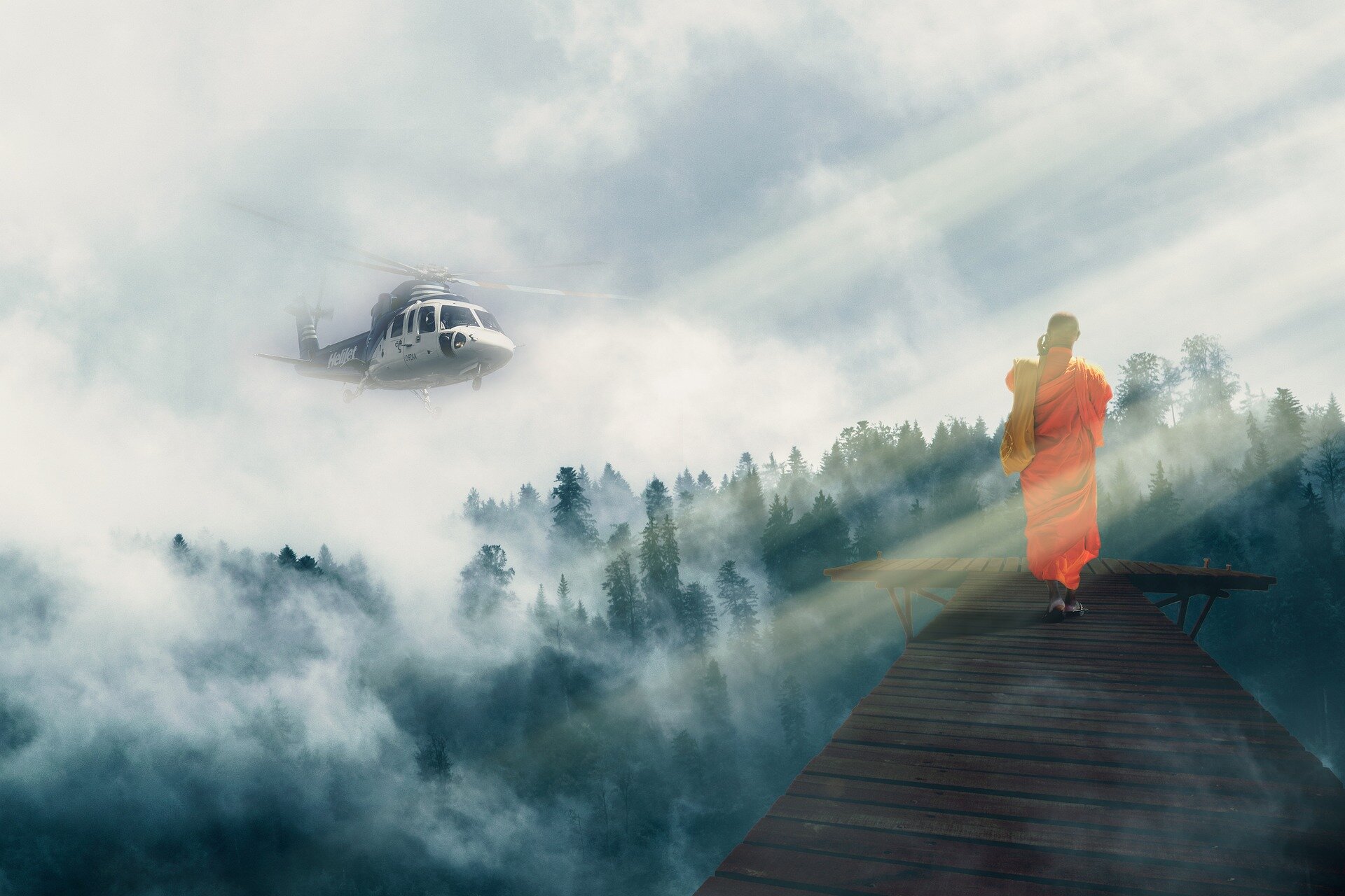 Ilustracja przedstawia drewniany most, który znajduje się nad zamglonym lasem. Na końcu mostu stoi mnich w pomarańczowej szacie. Z lewej strony nadlatuje helikopter. Na ilustrację z prawej strony padają promienie słoneczne. W tle znajduje się niebo z chmurami.