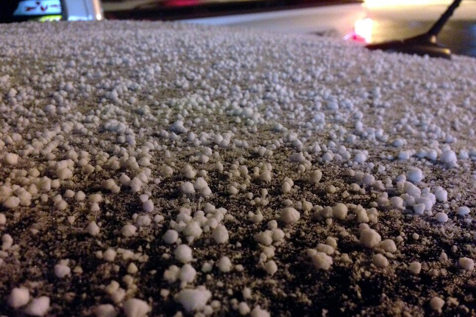 Fotografia barwna przedstawiająca krupy śnieżne (białe, porowate i kruche bryłki wielkości 1-5 mm)