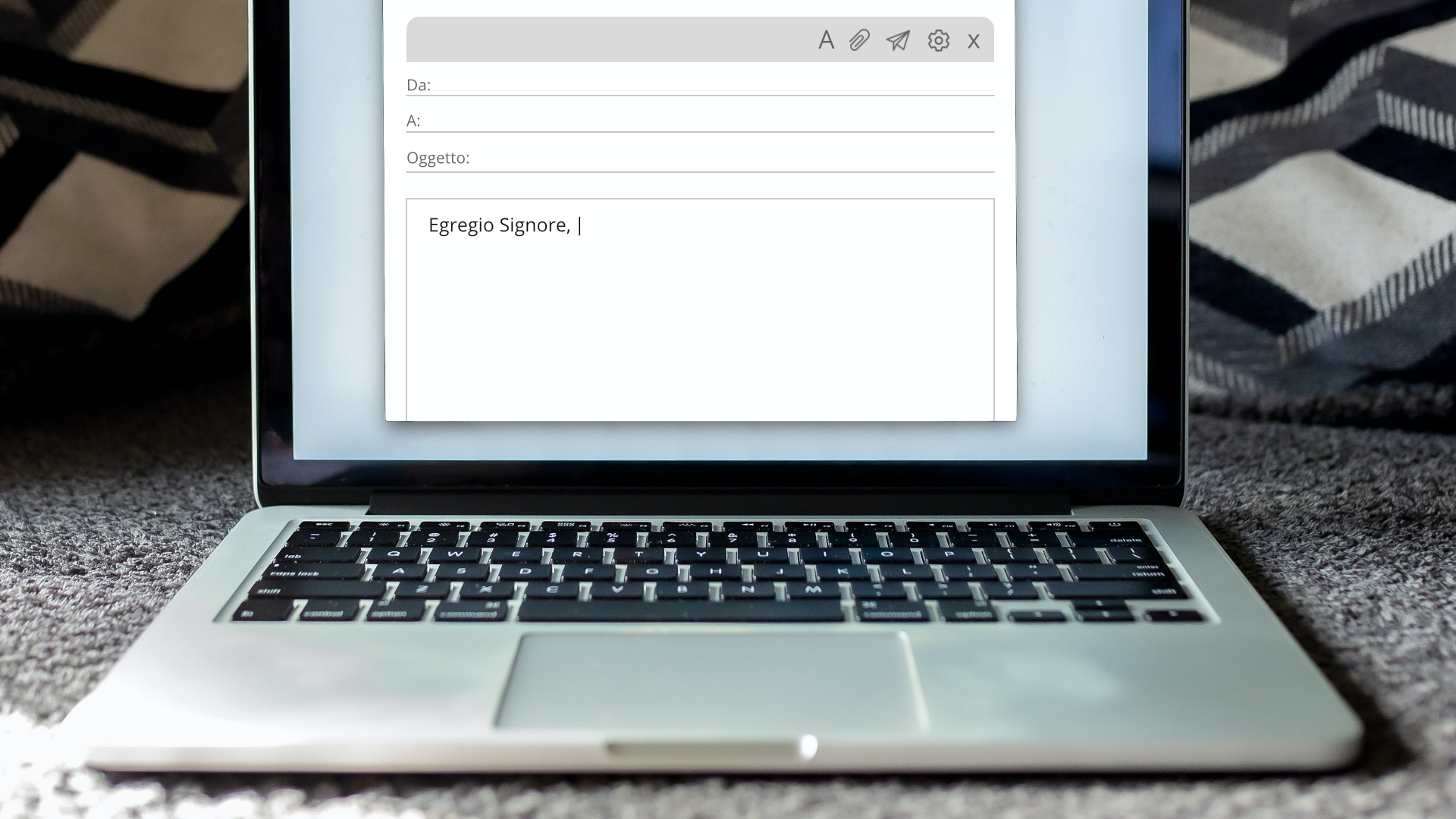 Zdjęcie przedstawia włączonego laptopa, na ekranie którego widoczny jest formularz maila.