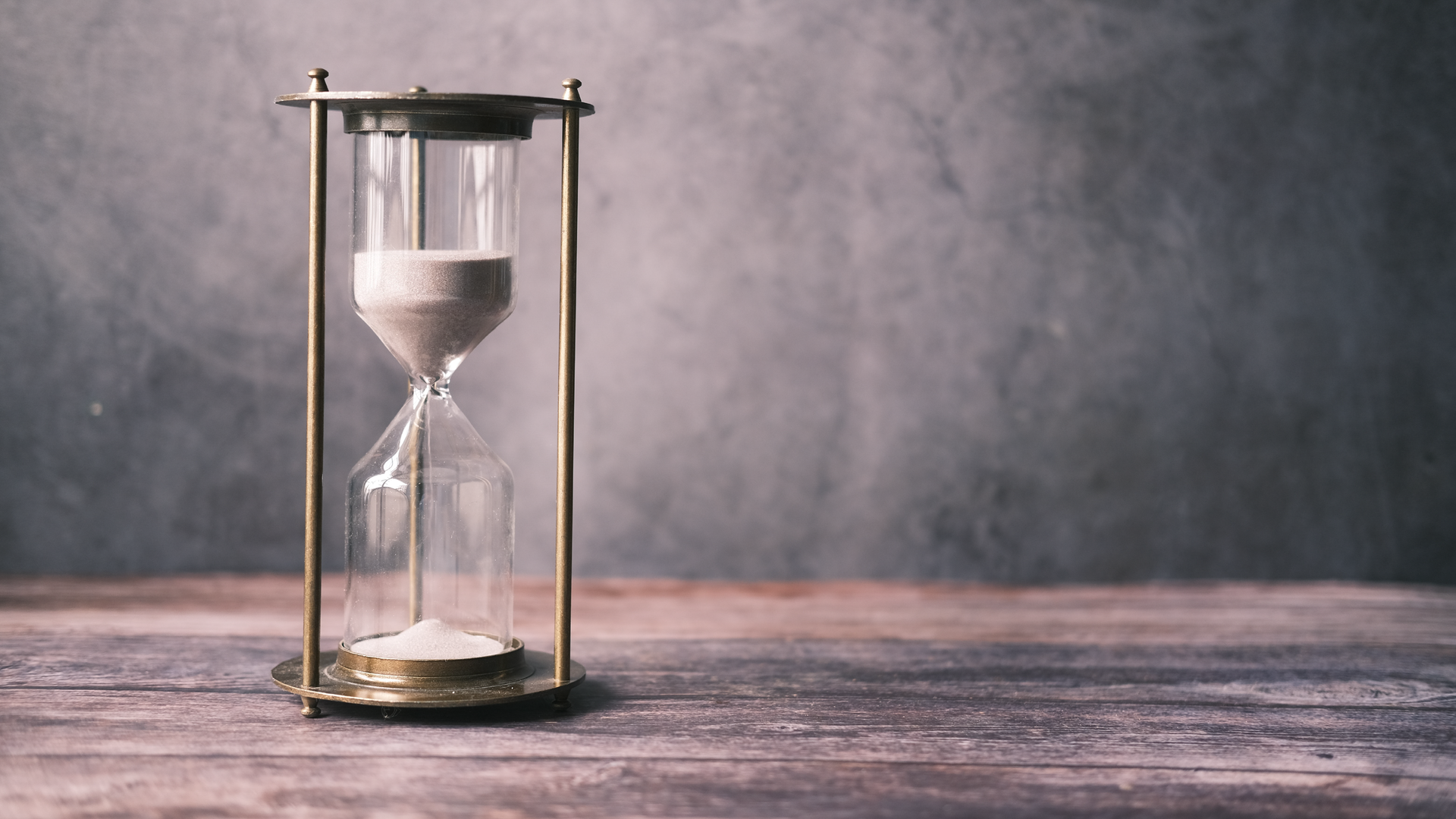 Zdjęcie przedstawia klepsydrę. Piasek znajduje się w górnej części klepsydry.