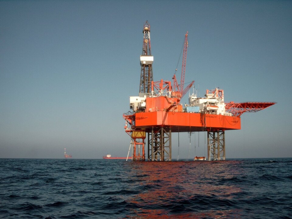 Na zdjęciu na pełnym morzu jest platforma wiertnicza. Jest zlokalizowana na stalowych podporach. 