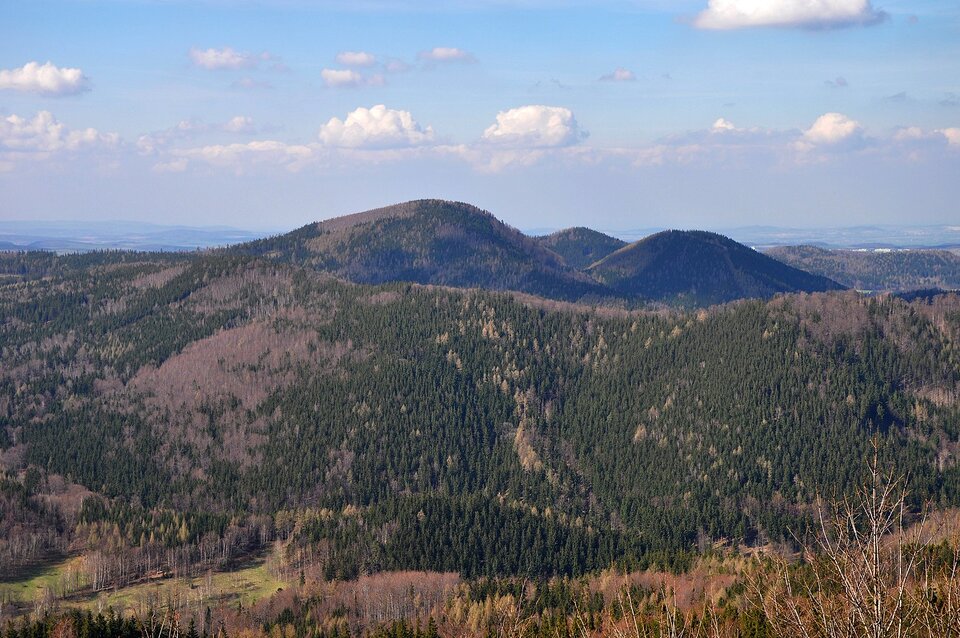 Zdjęcie przedstawia teren wyżynny. Wzniesienia są porośnięte roślinnością, mają zaokrąglone, łagodne wierzchołki.  