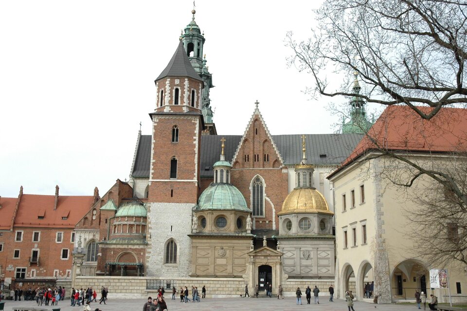 Ilustracja przedstawia widok na Katedrę św. Stanisława i św. Wacława na Wawelu w Krakowie, od strony południowej. Najbardziej przykuwającym uwagę elementem południowej fasady są dwie, niemal identyczne kaplice: kaplica Zygmuntowska i kaplica Wazów. Kaplica Zygmuntowska jest zwieńczona złoconą kopułą na ośmiobocznym bębnie z okrągłymi otworami okiennymi. Na szczycie kopuły znajduje się latarnia.