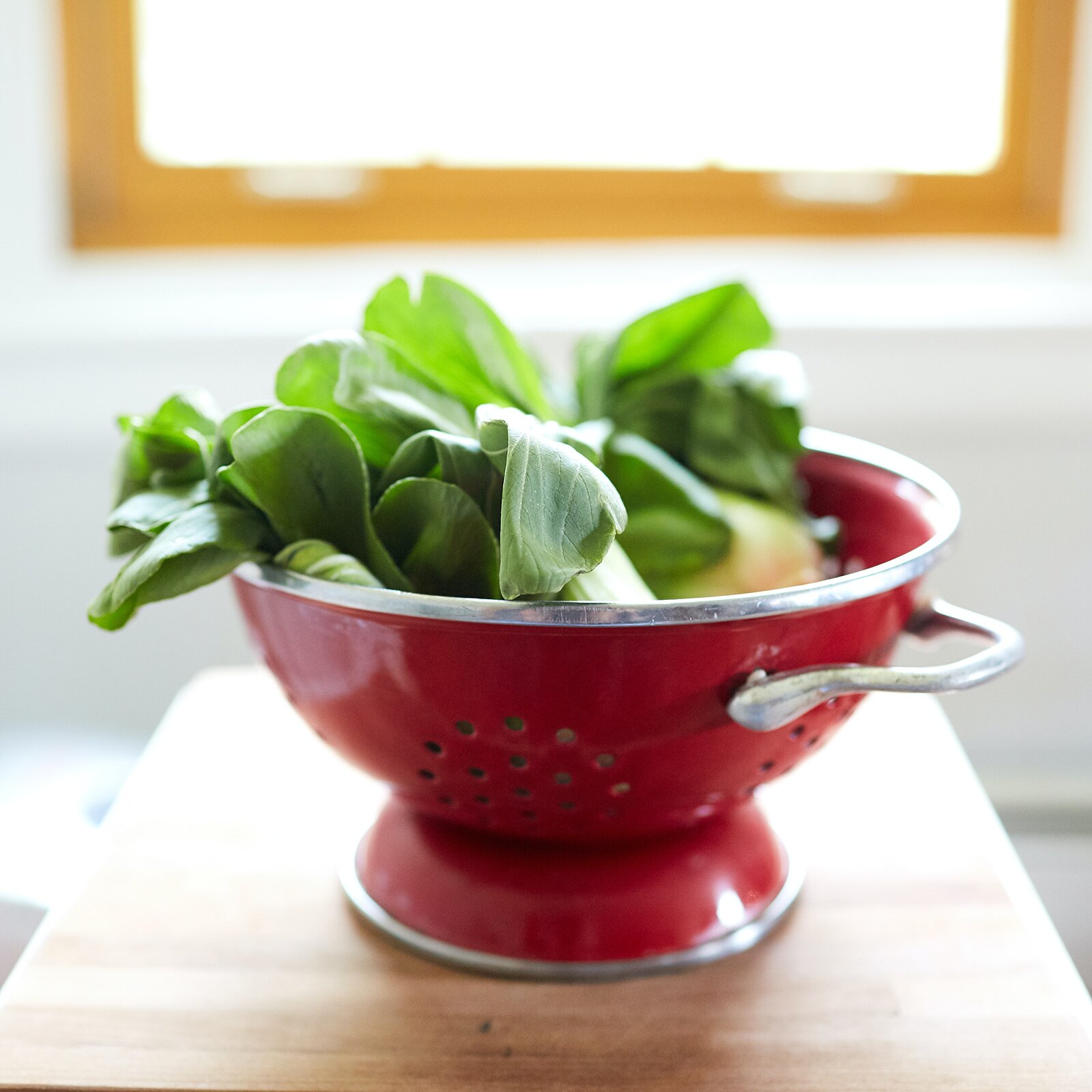 Zdjęcie przedstawia sitko wykonane ze stali nierdzewnej pomalowane na kolor czerwony, w którym znajdują się liście bazylii. Pod zdjęciem transkrypcja [odtwórz] 