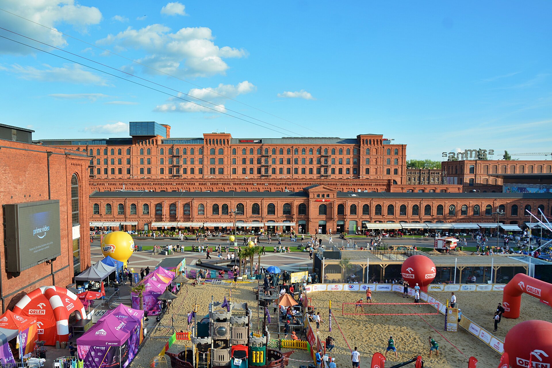 Zdjęcie przedstawia dawną fabrykę, tzw. „Manufakturę", przywróconą do użytku publicznego dzięki rewitalizacji. Jest to kompleks budynków  z czerwonej cegły, parterowy z rzędem dużych półokrągło zakończonych okien i znajdujące się za nim dwa kilkupiętrowe. Obecnie jest to wielofunkcyjne centrum handlowe odwiedzane przez setki klientów. Przed „Manufakturą" rozpościera się duży plac rekreacyjno‑komercyjny.