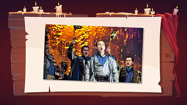 To dynamiczna scena z kilkoma mężczyznami na scenie. W centrum znajduje się mężczyzna z otwartymi ustami, wyglądający, jakby śpiewał lub wykrzykiwał. Jest ubrany w bogaty strój przypominający historyczne szaty – połyskującą, srebrzystą tunikę z wzorami i ciemne spodnie. Mężczyźni wokół niego również mają otwarte usta i podnoszą ręce, trzymając w niektórych przypadkach złote maski na patykach. Tło jest jasne, w odcieniach pomarańczowo‑żółtych, z rozmytymi plamami światła, tworzącymi wrażenie blasku.