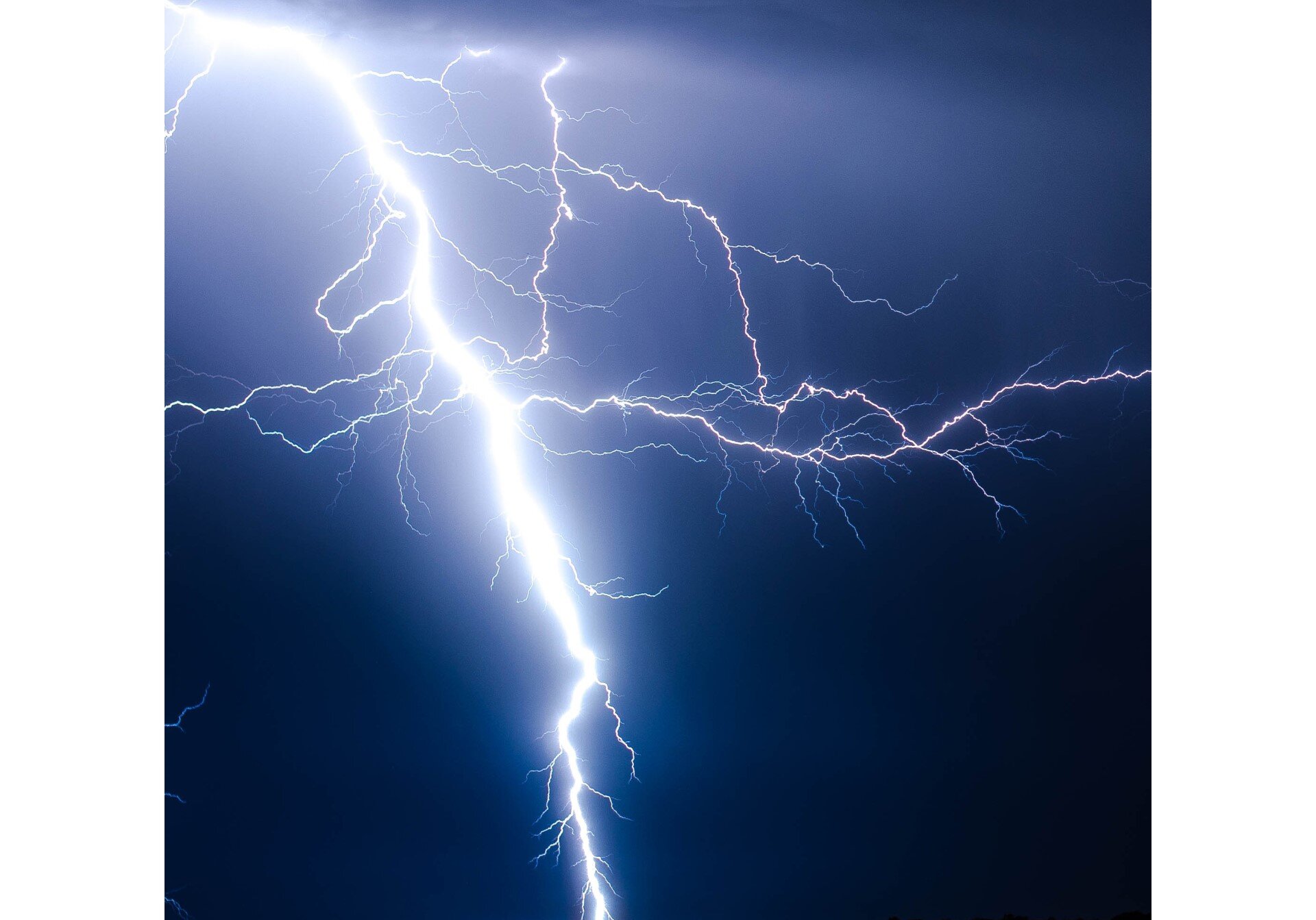 Zdjęcie przedstawia piorun na tle granatowego nieba.