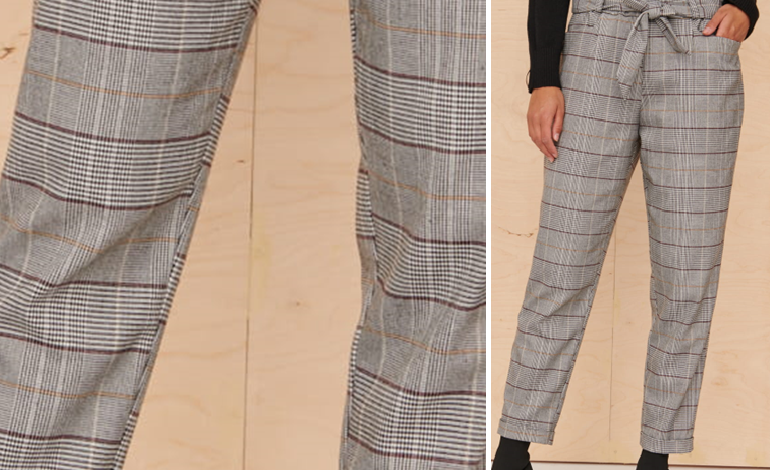 Zdjęcie przedstawia długie proste spodnie w kratkę. Kończą się przed kostką. Wzór kraty jest nieprawidłowo dopasowany na zszyciu spodni. 