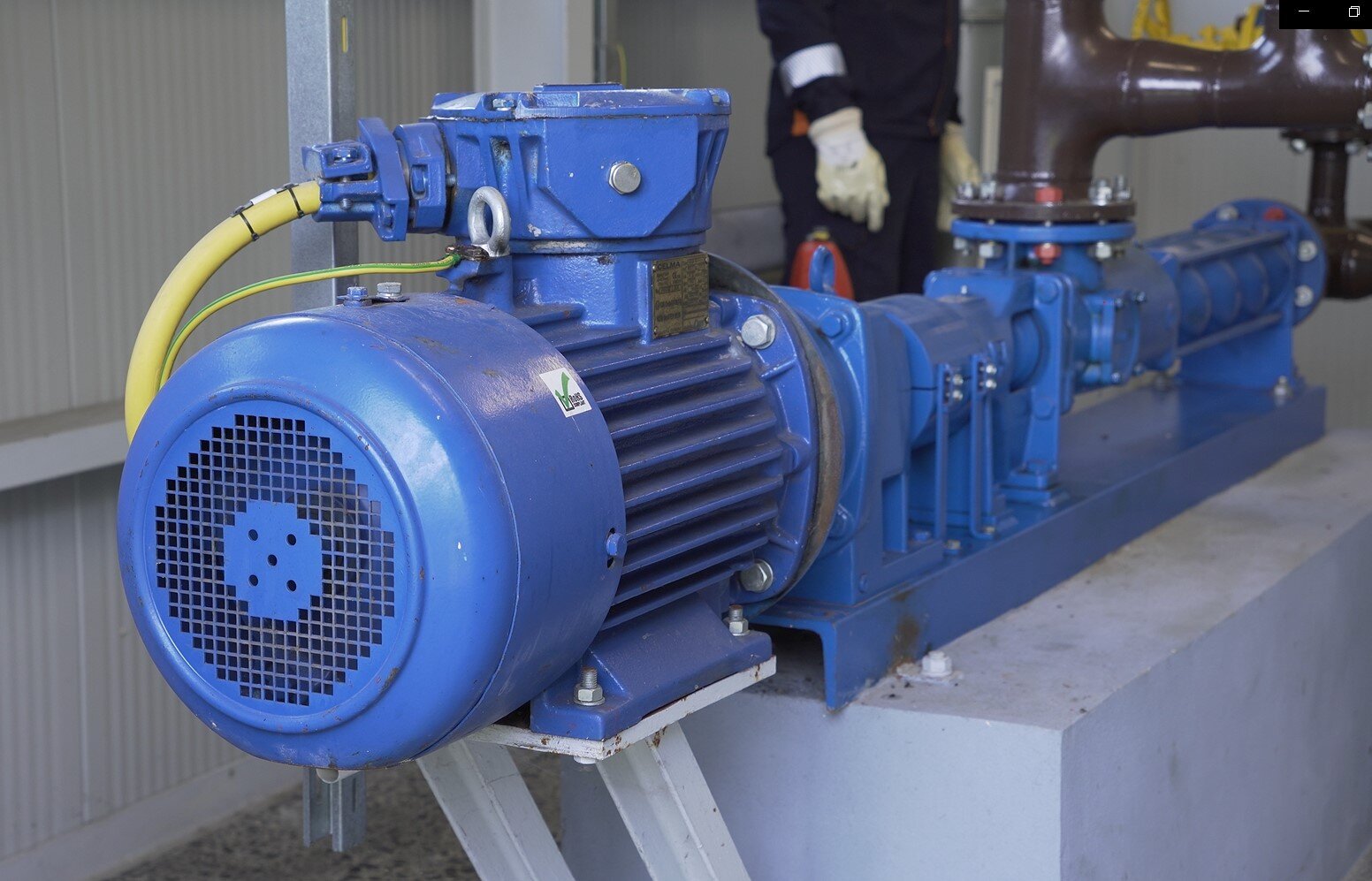 Na ekranie widoczna jest pompa śrubowa. Pompa śrubowa służy do tłoczenia ropy naftowej.Na pierwszym planie zdjęcia znajduje się cylindryczny silnik pompy. W oddali widać cylindryczny element, w którym znajduje się ramię wymuszające ruch świdra oraz element, w którym znajduje się świder. W połowie pompy znajduje się połączenie z brązową rurą wychodzącą w górę. Do silnika dołączony jest żółty przewód.