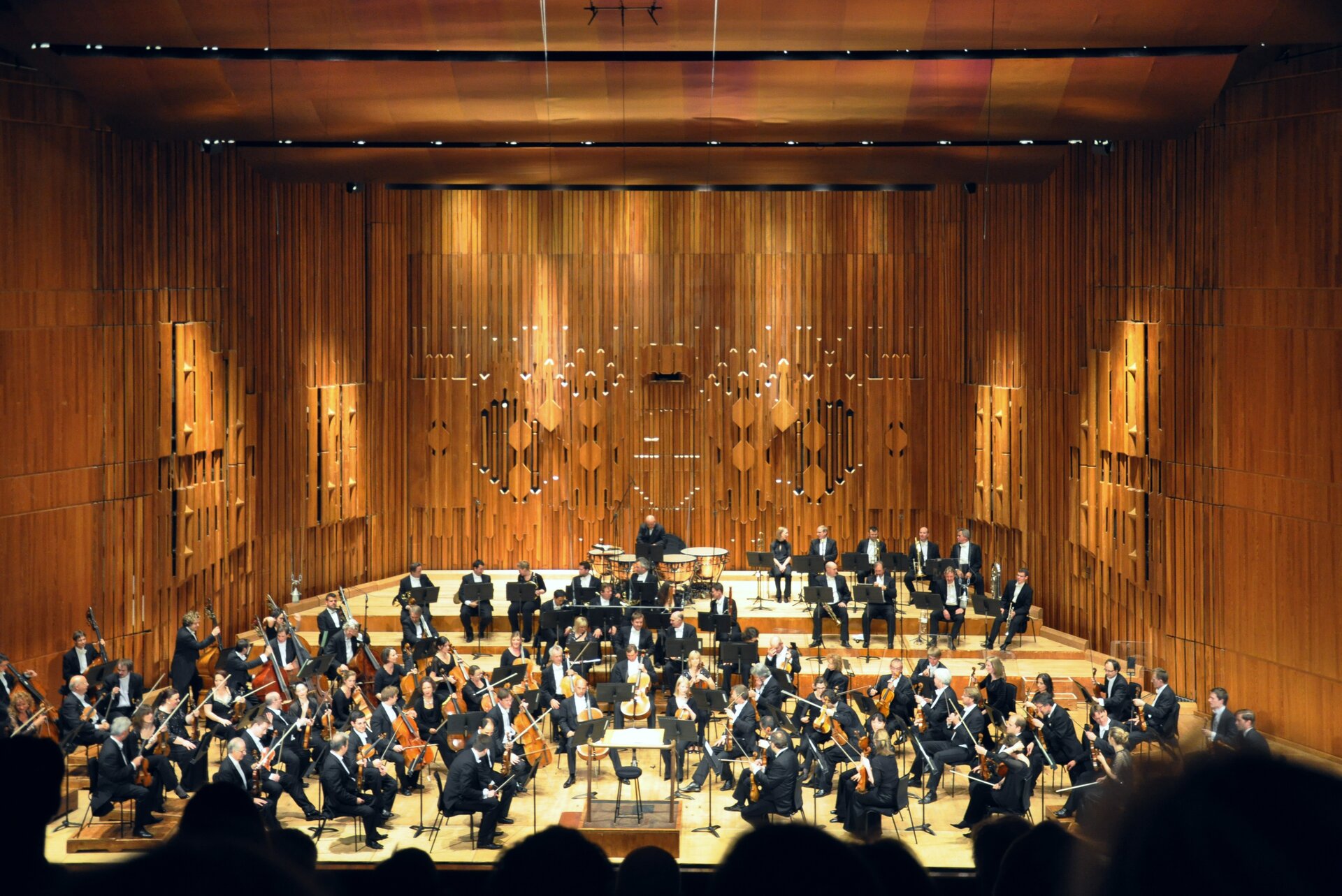 Ilustracja przedstawia: The London Symphony Orchestra w Barbican Hall. Na zdjęciu widać orkiestrę w trakcie koncertu.
