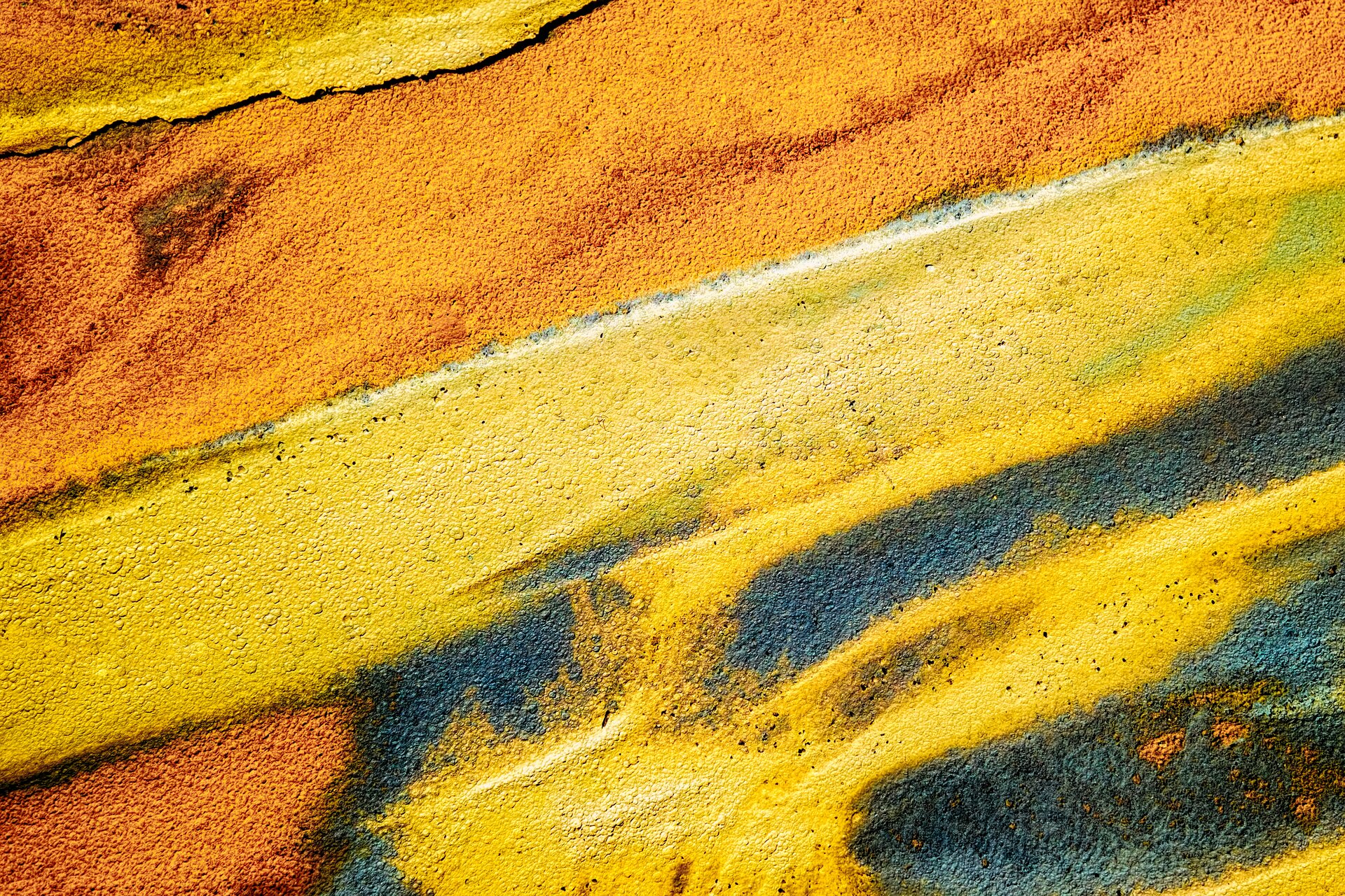 Zdjęcie przedstawia przykład kompozycji otwartej. Widzimy położone pasy farby: pomarańczowej, żółtej i przenikające się kolory pomarańczowe, żółte, niebieskie.