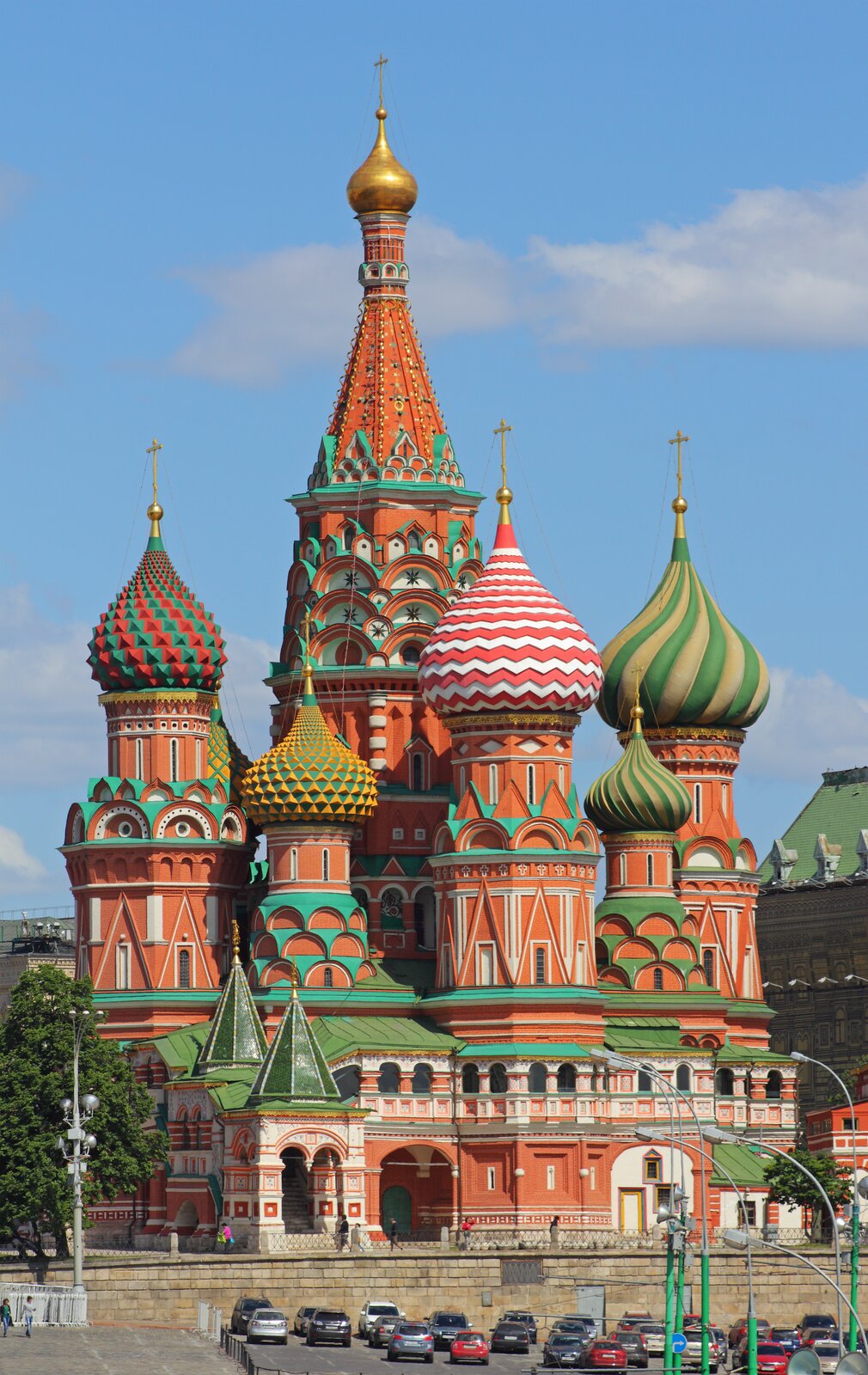 Zdjęcie przedstawia sakralną budowlę prawosławną w jaskrawych kolorach. Świątynia zbudowana jest z ośmiu oddzielnych cerkwi, z których każda została zwieńczona charakterystyczną kopułą, na której czubku ustawiono prawosławne, złote krzyże. 