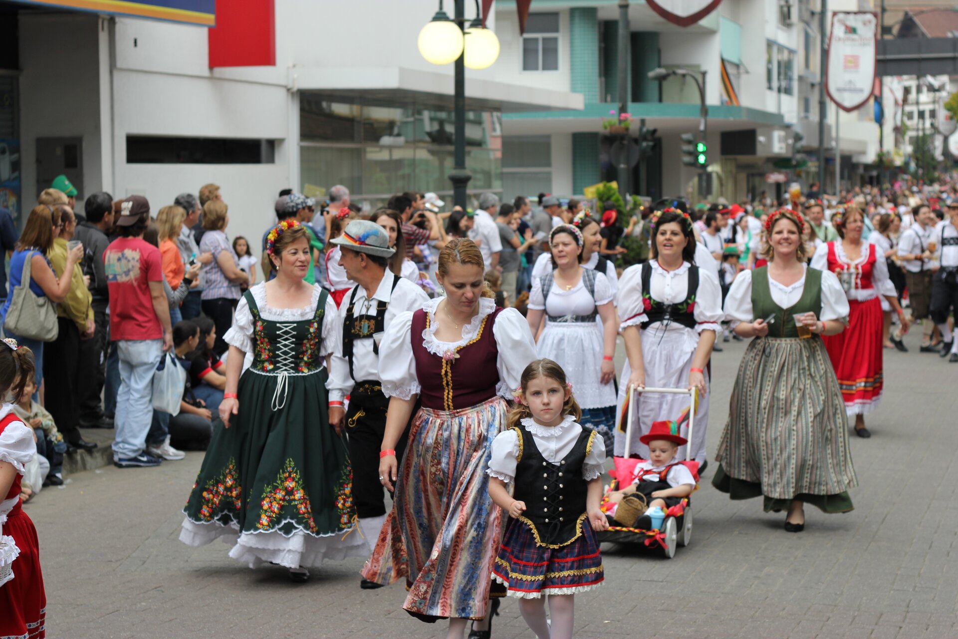 Zdjęcie przedstawia grupę kobiet i dzieci w tradycyjnych, kolorowych haftowanych sukniach.