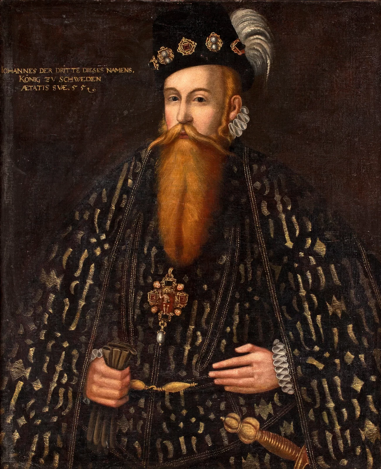 Kliknij, aby powiększyć. Obraz przedstawiający portret mężczyzny. Ma bardzo długą brodę oraz wąsy. W prawej ręce trzyma rękawiczki, a lewą trzyma na wysokości pasa. Ubrany w szatę, tego samego wzoru co narzuta na plecach (ciemny kolor ze złotymi kształtami).