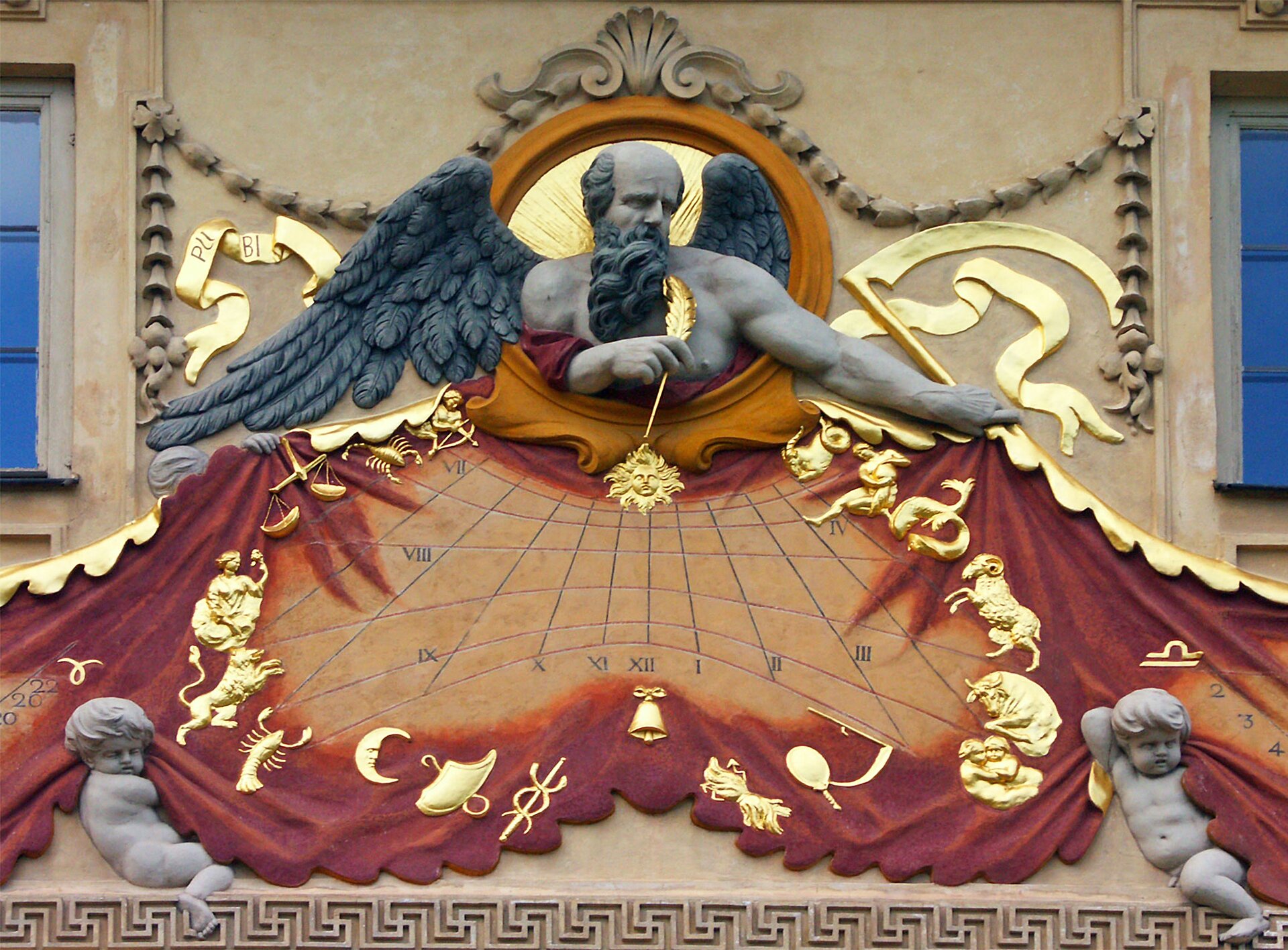 Ilustracja przedstawia zegar słoneczny– motyw zdobniczy pałacu wilanowskiego. W centrum widnieje marmurowe popiersie boga Chronosa. Przedstawiony jest jako łysiejący starzec z długą czarną brodą i skrzydłami. Poniżej jego piersi znajduje się zegar, rozpostarty na płaskorzeźbie imitującej bordową tkaninę. U dołu podtrzymują ją dwa amorki. Dokoła tarczy zegara umieszczono wyobrażenia znaków zodiaku. Wskazówką rzucającą cień na tarczę zegara jest złote pióro trzymane przez boga w prawej dłoni.