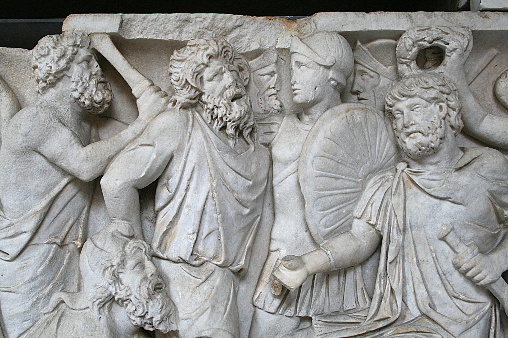 Na ilustracji przedstawiono kamienną płaskorzeźbę. Jest to relief z rzymskiego sarkofagu ukazujący poddanie się Sarmatów żołnierzom rzymskim. Postaci ukazane są z profilu. Na pierwszym planie uzbrojony żołnierz rzymski w hełmie i z tarczą stoi twarzą w twarz z Sarmatą. Jest to mężczyzna o długich kręconych włosach, ma bujny zarost, ubrany jest w lekką szatę. Za nim stoi jego towarzysz z wyciągniętą ręką, w której trzyma miecz. Poniżej widoczna jest jedynie głowa i górna część tułowia innego Sarmaty, który prawdopodobnie klęczy. W prawym dolnym rogu stoi mężczyzna, który wyciąga do niego rękę.