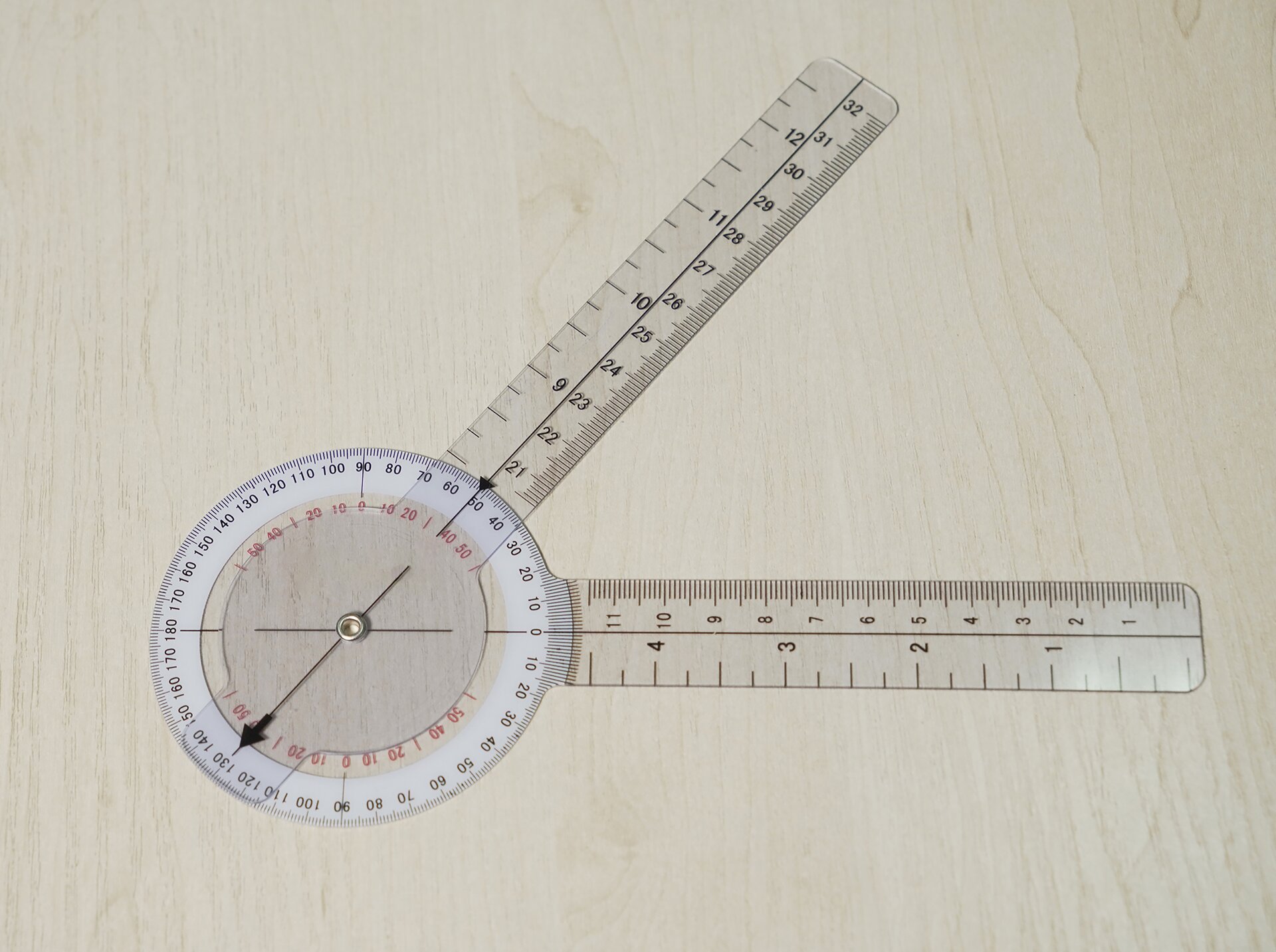 Zdjęcie przedstawia przyrząd przeznaczony do mierzenia kątów. Zbudowany jest z dwóch ruchomych ramion, linijek połączonych ze sobą na jednym końcu okrągłym kątomierzem. 