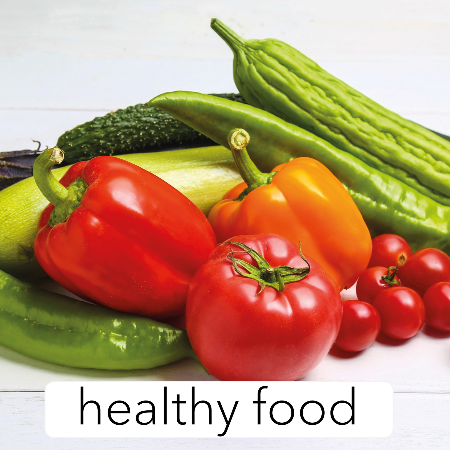Zdjęcie przedstawia ogórki szklarniowe, papryki, pomidorki i kabaczki. Na ilustracji znajduje się u dołu podpis:  healthy food 