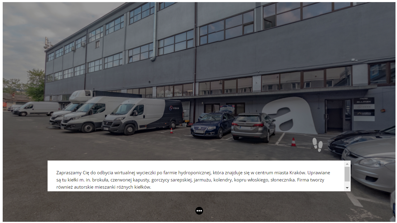 Widok planszy głównej, od której rozpoczyna się wycieczka. Zdjęcie przedstawia samochody zaparkowane przed halą lub magazynem. w dolnej części ekranu znajduje się biały pasek z tekstem powitalnym.