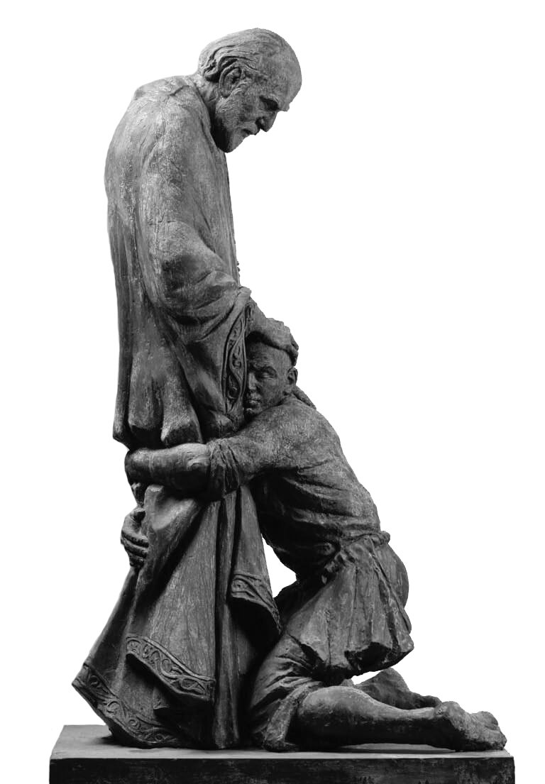 Fotografia barwna w układzie pionowym, która ukazuje widok z boku na rzeźbę przedstawiającą bosonogiego syna klęczącego z szeroko rozstawionymi kolanami u stóp ojca i przytulającego się do niego prawym policzkiem, zwróconej w stronę widza twarzy. Lewą ręką w połowie uda, a prawą niżej, na wysokości kolan obejmuje ojcowskie nogi. Ten jest odziany szczelnie po szyję w długą, powłóczystą szatę. Jego głowa dominuje nad klęczącą postacią i ukazana została profilem, jest pochylona, łysiejąca od czoła, ale pokryta w tylnej części dość długimi, zaczesanymi za uszy włosami. Widoczne są też dłonie. Wysunięte są one z szerokich rękawów wykończonych podobnie jak brzegi odzienia szeroką bordiurą z roślinnym ornamentem i spoczywają na wystrzyżonej głowie syna. Ten uspokojony gestem przebaczenia przymknął ufnie oczy. Górna część stroju, krótka przepasana sznurem tunika, ma podwinięte powyżej łokci rękawy, obnażając tym przedramiona. Podwinięte nogawki spodni ukazują gołe łydki. Lewa stopa spoczywa bokiem na ziemi. Prawa, której uniesiona pięta w tle styka się ze zwisającą fałdą stroju, oparta została tak, że spoczywa wierzchnią stroną palców.
