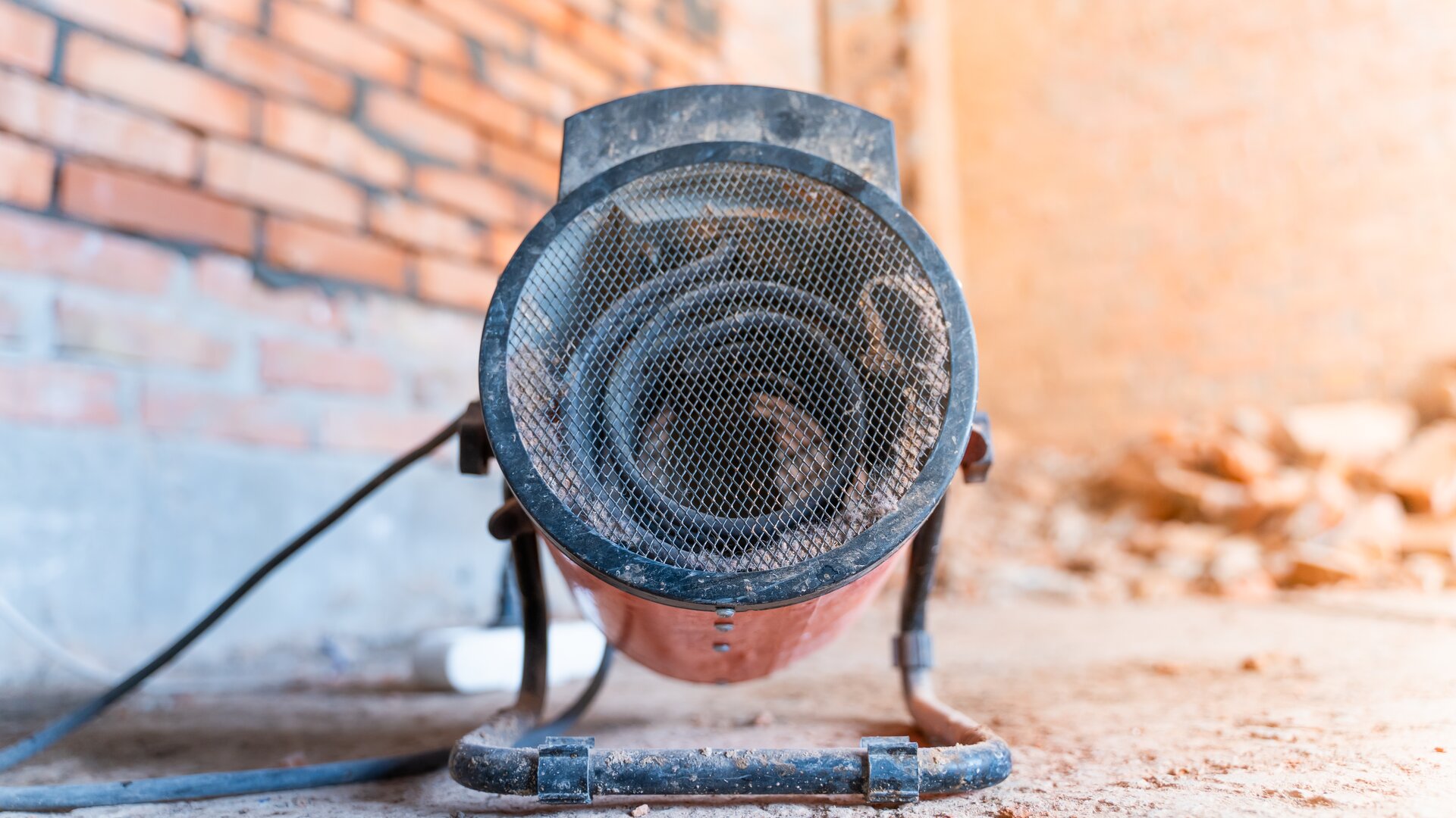 Zdjęcie przedstawia nagrzewnicę elektryczną. W przedniej części posiada siatkę, za którą znajduje się nawiew.