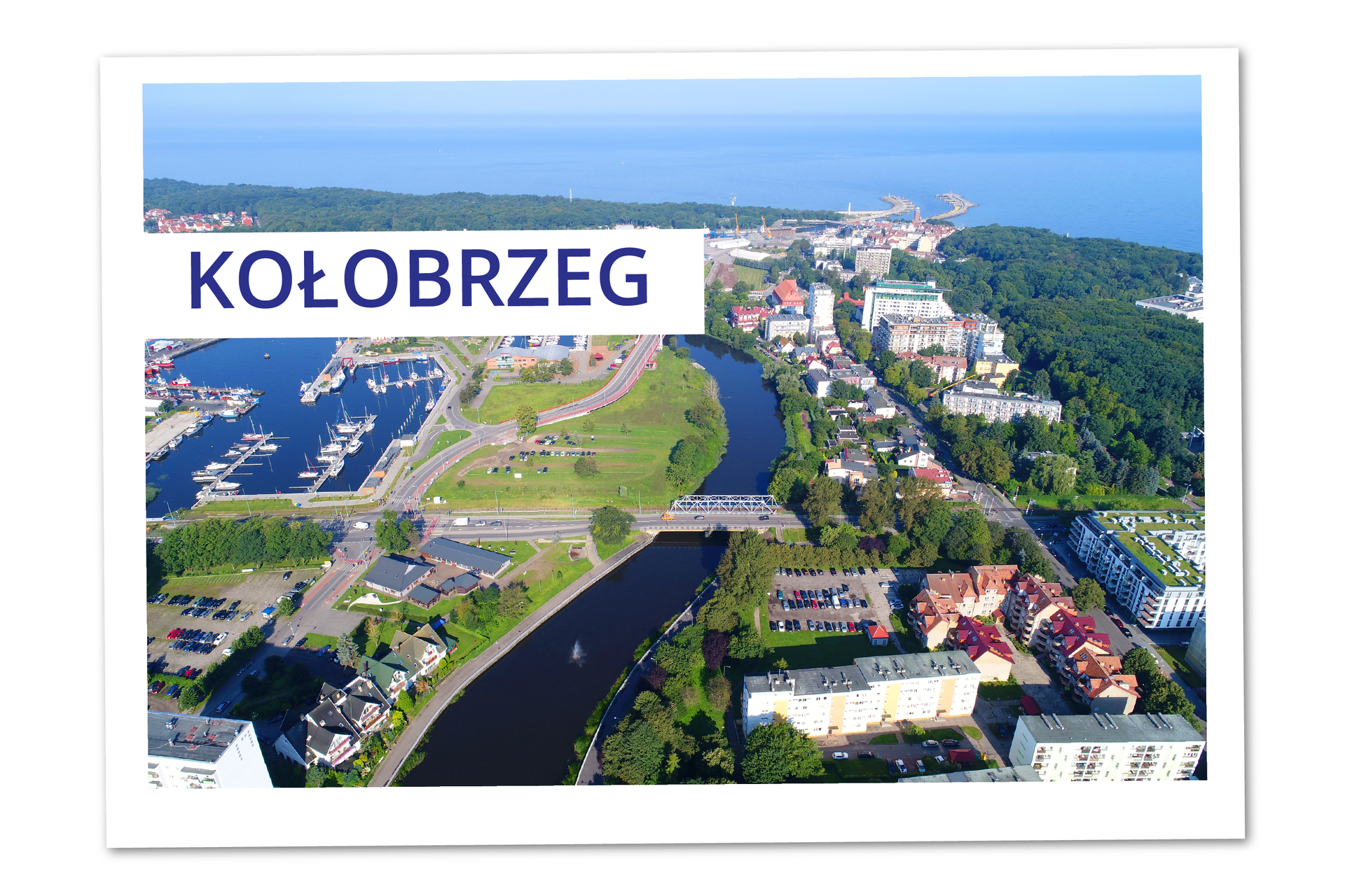 Ilustracja przedstawia widok z góry na miasto Kołobrzeg. Położone w niewielkiej odległości od morza miasto podzielone jest przez rzekę.