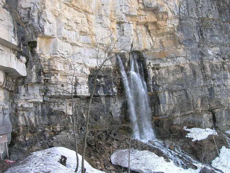 Źródło szczelinowe, Pesio , Alpy Liguryjskie
Na fotografii widać wysoką formację skalną z której wypływa dużym strumieniem woda.