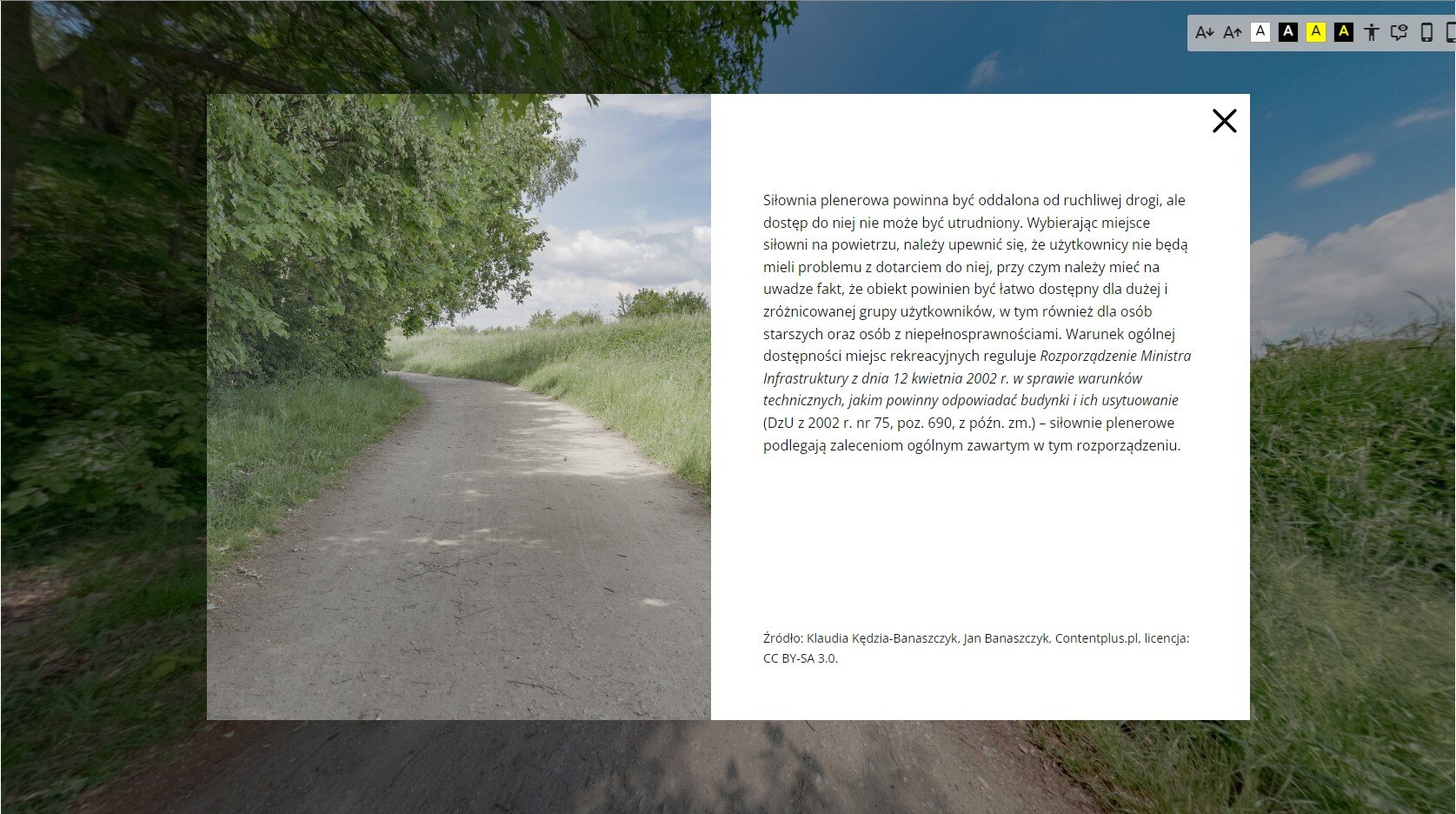 Ilustracja przedstawia przykładową planszę prezentującą informacje na temat przedstawionego miejsca.  Na środku ekranu widoczne jest się pole. Podzielone zostało na dwie części. Z lewej strony znajduje się fotografia miejsca, na którym umieszczona została ikona z literą „i”. Z prawej strony znajduje się plansza z informacjami dotyczącymi tego miejsca. Na samym dole umieszczone zostało źródło tekstu. W prawym górnym rogu ekranu znajduje się przycisk w kształci litery „x”. 