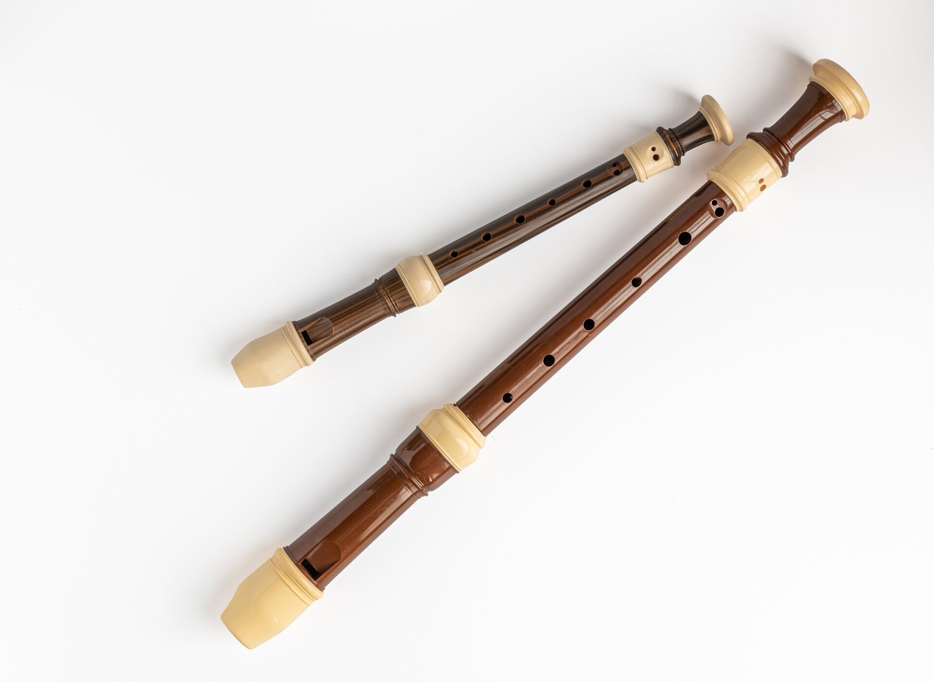 Na wykonanym zdjęciu z góry, zaprezentowane zostały dwa instrumenty, jakimi są flety proste. Jeden z nich jest dużych rozmiarów, natomiast drugi jest o wiele mniejszy. Oba flety są wykonane w przewadze koloru brązowego, a ich ustniki i nieliczne fragmenty są w beżowym kolorze.