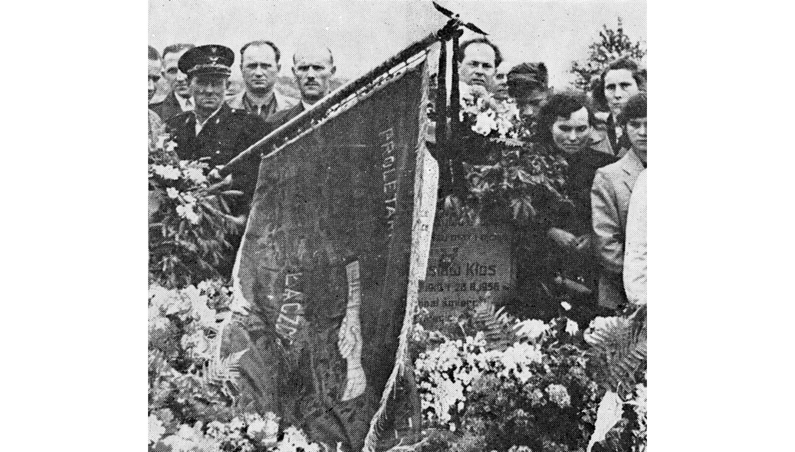 Czarno-biała fotografia przedstawiająca pogrzeb jednej z ofiar starć z wojskiem. Wokół nagrobka tłum ludzi z kwiatami i sztandarem (1956 r.).