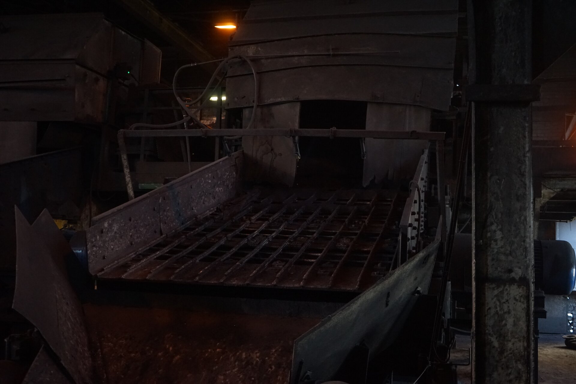 Zdjęcie przedstawia przesiewacz wibracyjny. Z komory, znajdującej się w górnej części urządzenia, spada nadawa. Kierowana jest na sita zamontowane pod skosem względem płaszczyzny poziomej. Ziarna zostają odsiane, dzięki drganiom zapewnianym przez generator wibracji. Na pierwszym planie znajdują się zsypy. Za ich pośrednictwem odprowadzana jest sklasyfikowana nadawa. Poniżej zdjęcia widoczny jest przycisk multimedialny z nagraniem audio. Treść nagrania jest zgodna z tytułem zdjęcia.