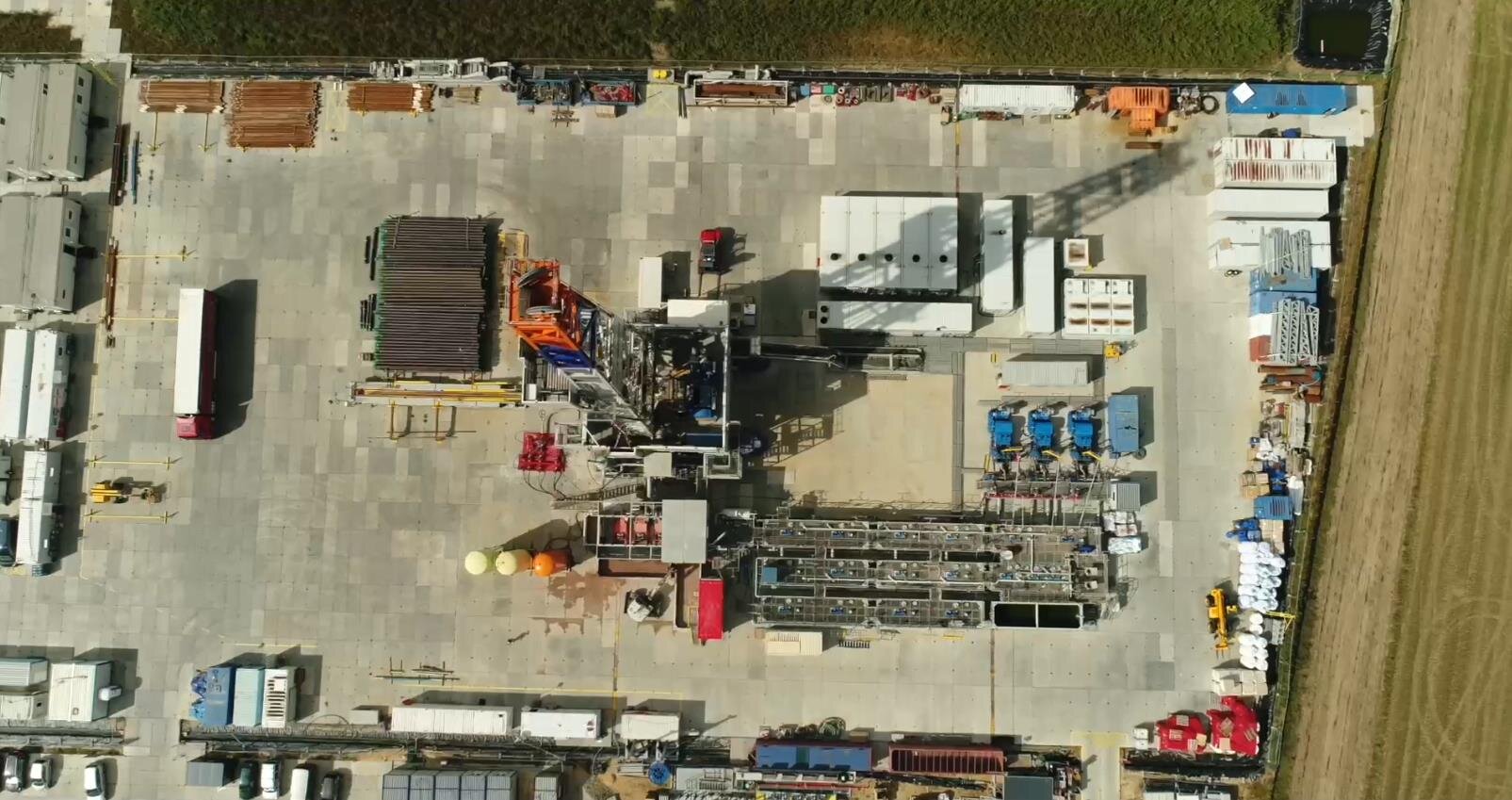 Na zdjęciu widoczny jest wieżomaszt wraz z placem widoczny z lotu ptakaPlac wiertniczy widoczny jest pod kątem lotu ptaka. Plac ma kształt prostokąta. Podstawa placu jest wyłożona betonowymi płytami. W centralnym punkcie placu znajduje się wieżomaszt. Wieżomaszt jest w kształcie litery A. Wieżomaszt ma dwa galerie. Na dolnej większej galerii znajduje się podbudówka. Podbudówka wykonana jest z blachy falistej. Po obwodzie placu znajdują się obiekty o kształcie prostokąta.Wieżomasz znajduje się pomiędzy małymi obiektami przypominającymi kontenery. W tle zdjęcia widać tereny leśne.