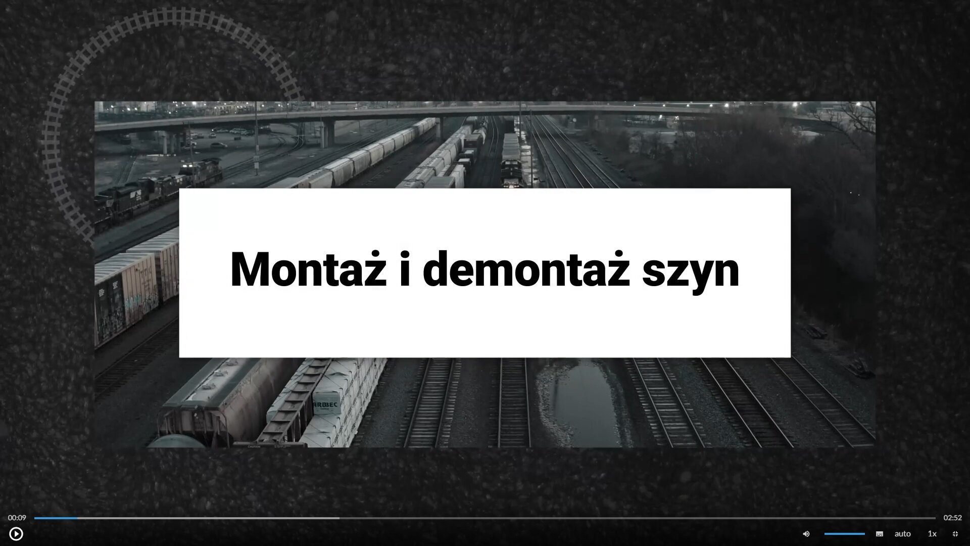 Przykładowy widok planszy filmu. Tytuł: Montaż i demontaż szyn; obok znajduje się widok stacji kolejowej wraz z pociągami towarowymi. Poniżej znajduje się menu w poziomie, a w nim od lewej: przycisk uruchomienia i pauzowania filmu, wybór poziomu głośności, opcja włączenia napisów, opcja włączenia audiodeskrypcji, opcja auto, opcja ustawienia prędkości odtwarzania, opcja trybu ekranowego.
