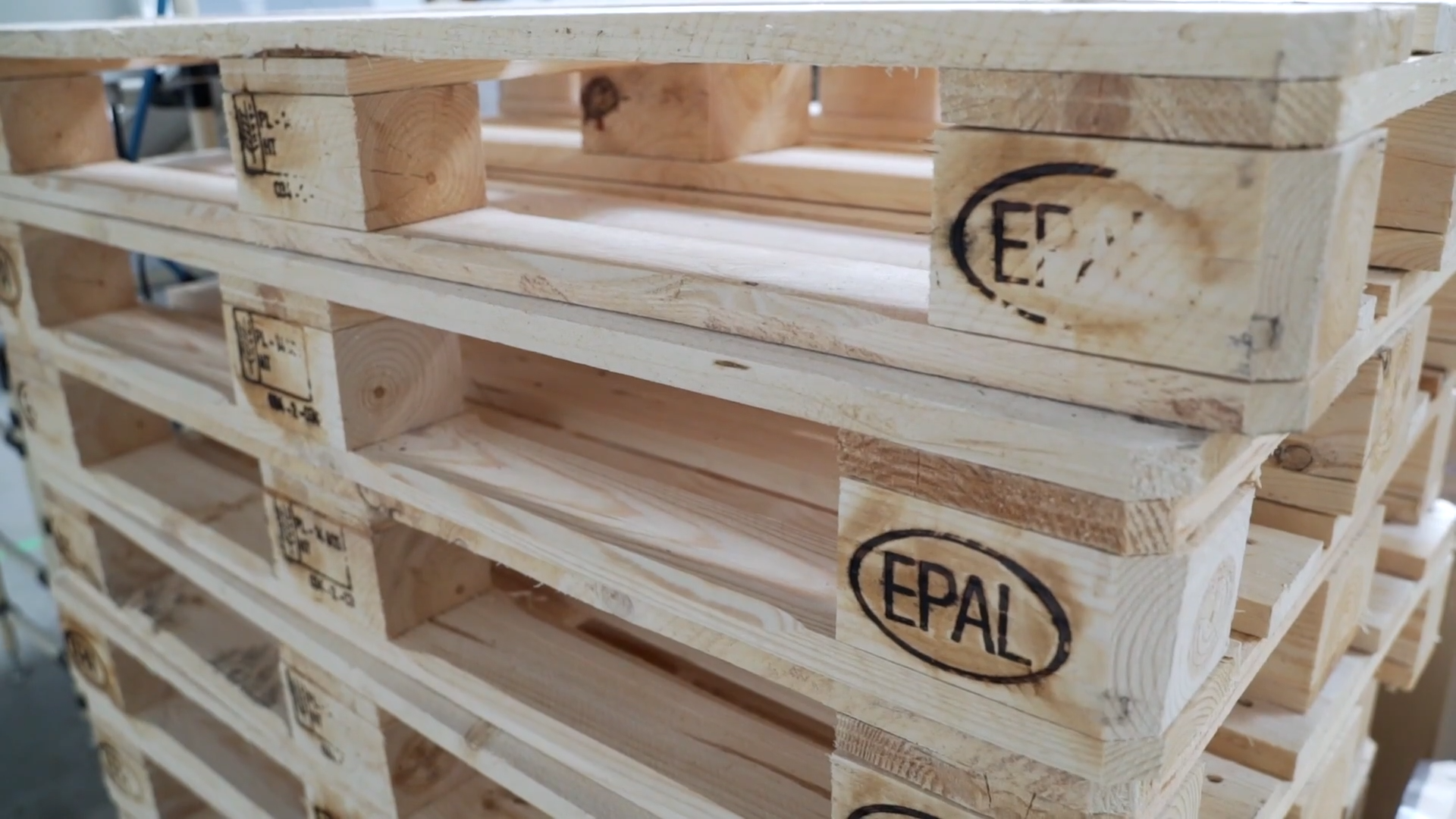 Zdjęcie przedstawia spiętrzone palety typu EPAL.