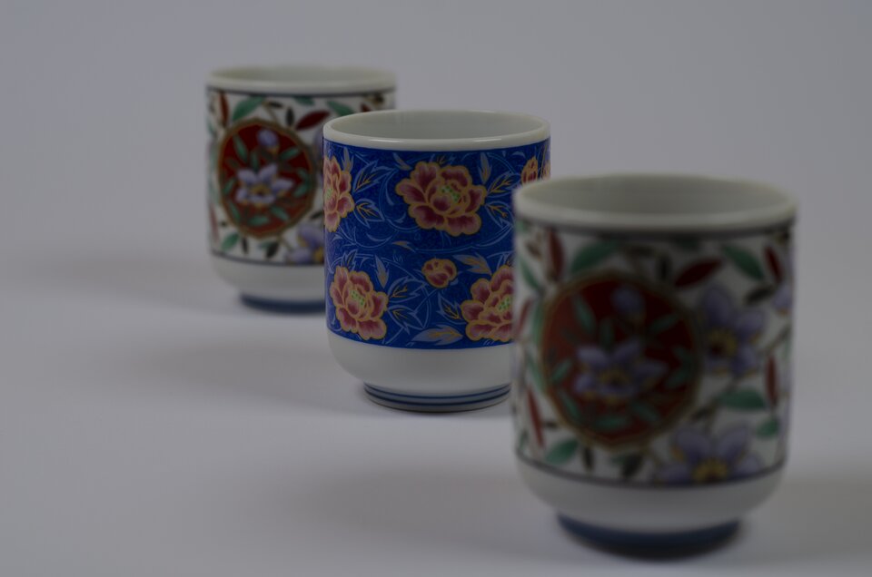 Niedoświetlona fotografia kubków ustawionych w perspektywie zbieżnej. Brak widocznych szczegółów w ciemnych partiach obrazu. 